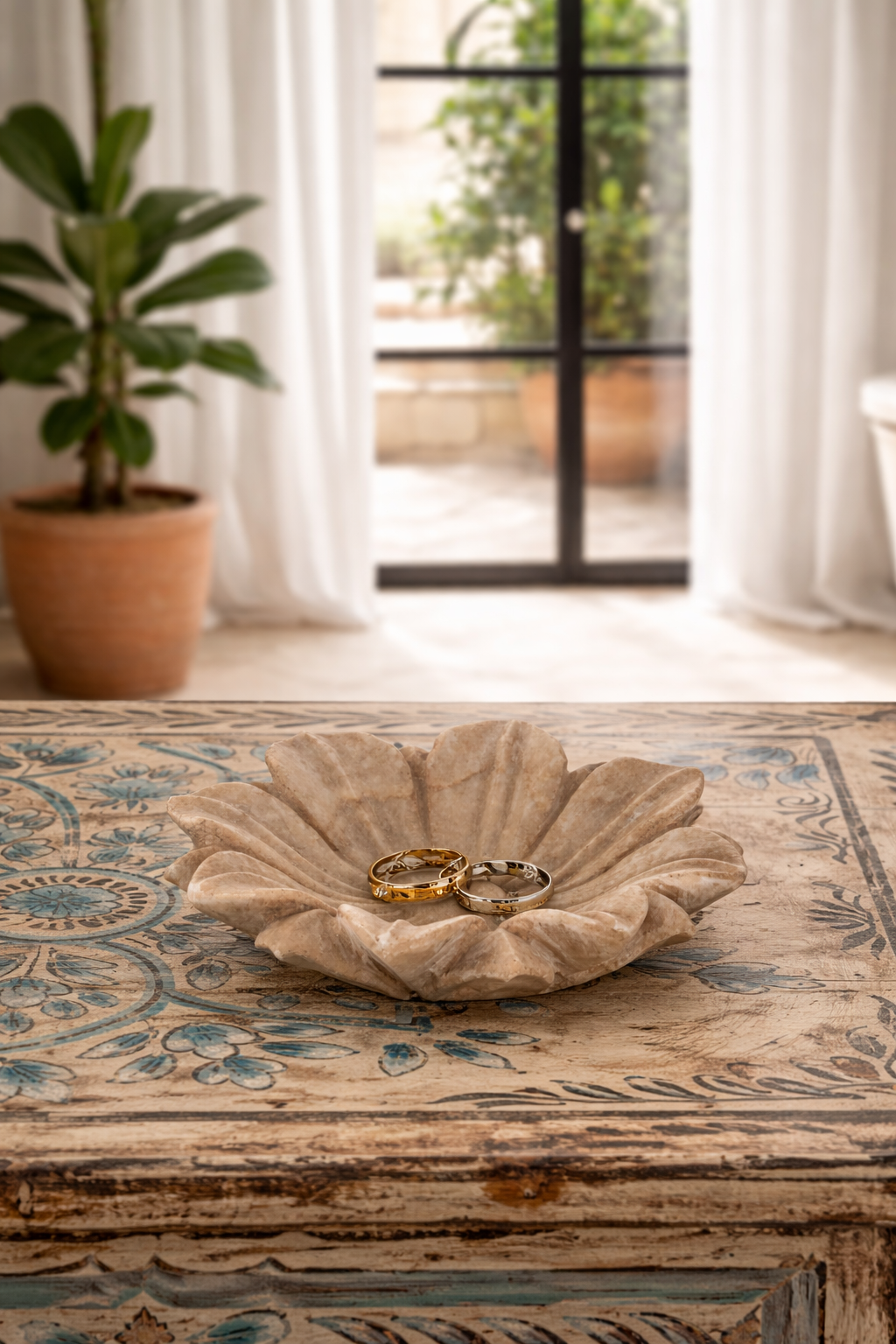 Lifestyle image of a of a hand-carved marble flower plate Manvik with sculpted petal design. A vintage home accessory and unique Indian decoration, perfect for soap, jewellery, or sweets in vintage home decor settings.