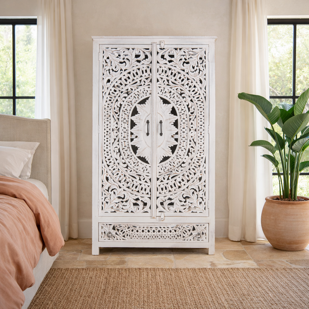 Lifestyle image of a hand-carved mango wood wardrobe with floral and geometric patterns and white-washed finish – carved wooden furniture for boho chic and Mediterranean-inspired interiors.