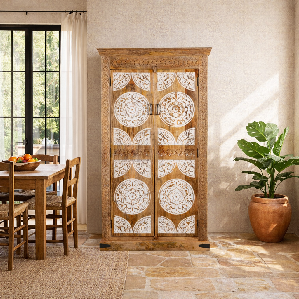 Lifestyle image of a carved wood furniture wardrobe made from mango wood with whitewashed floral doors, wooden wardrobe in Ibiza-inspired style, 100 × 40 × 180 cm.