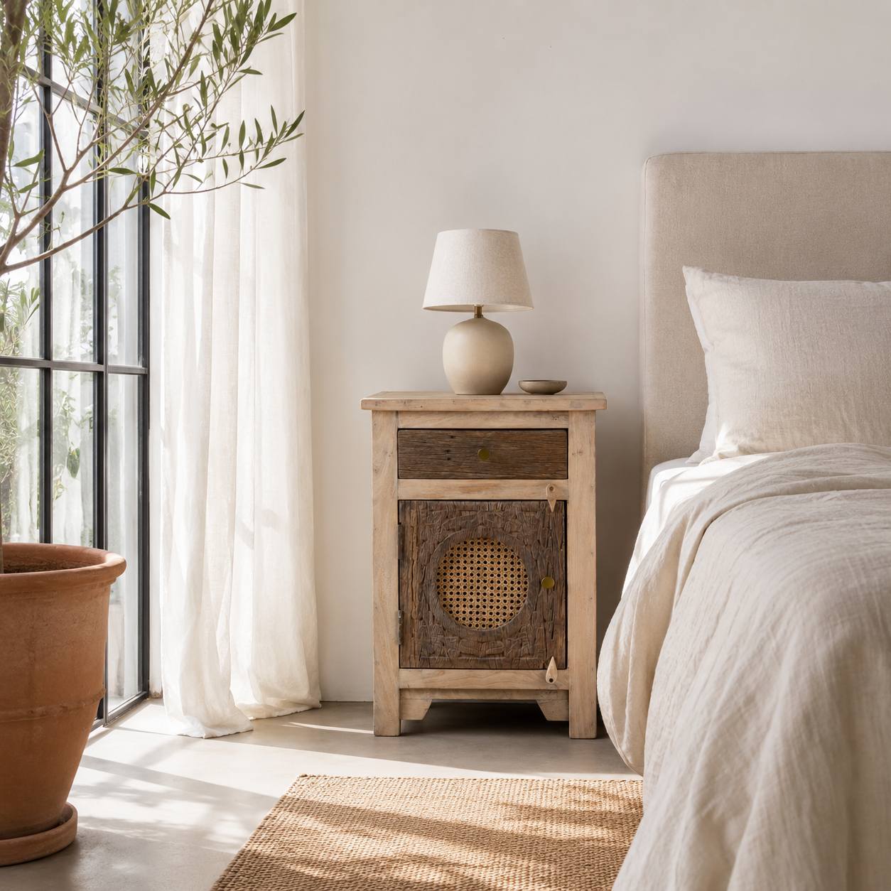 Lifestyle image of a Milan hand carved reclaimed wood nightstands with woven rattan inserts, drawer storage, cabinet doors, and warm natural boho style design.