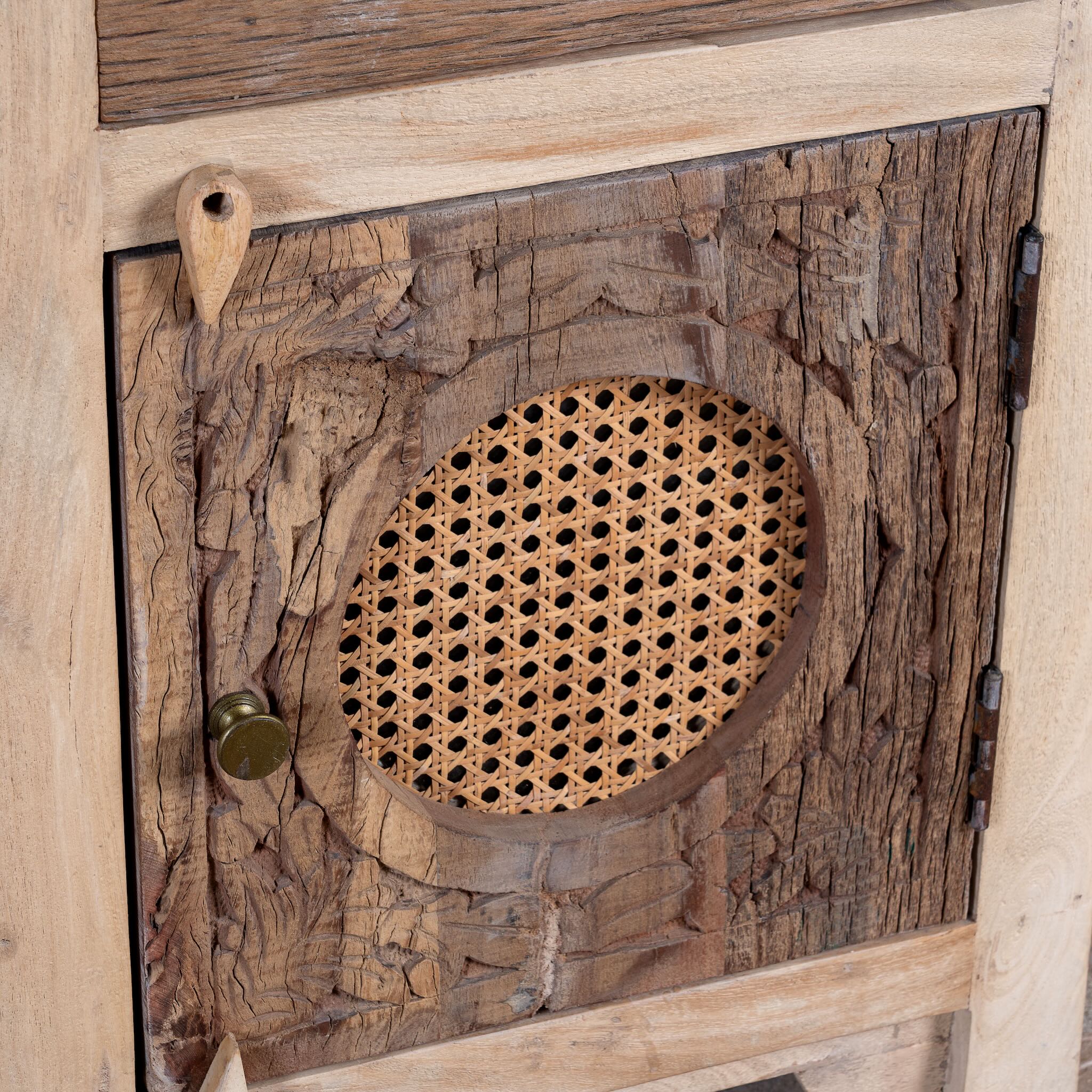 Close up image of a Milan hand carved reclaimed wood nightstands with woven rattan inserts, drawer storage, cabinet doors, and warm natural boho style design.