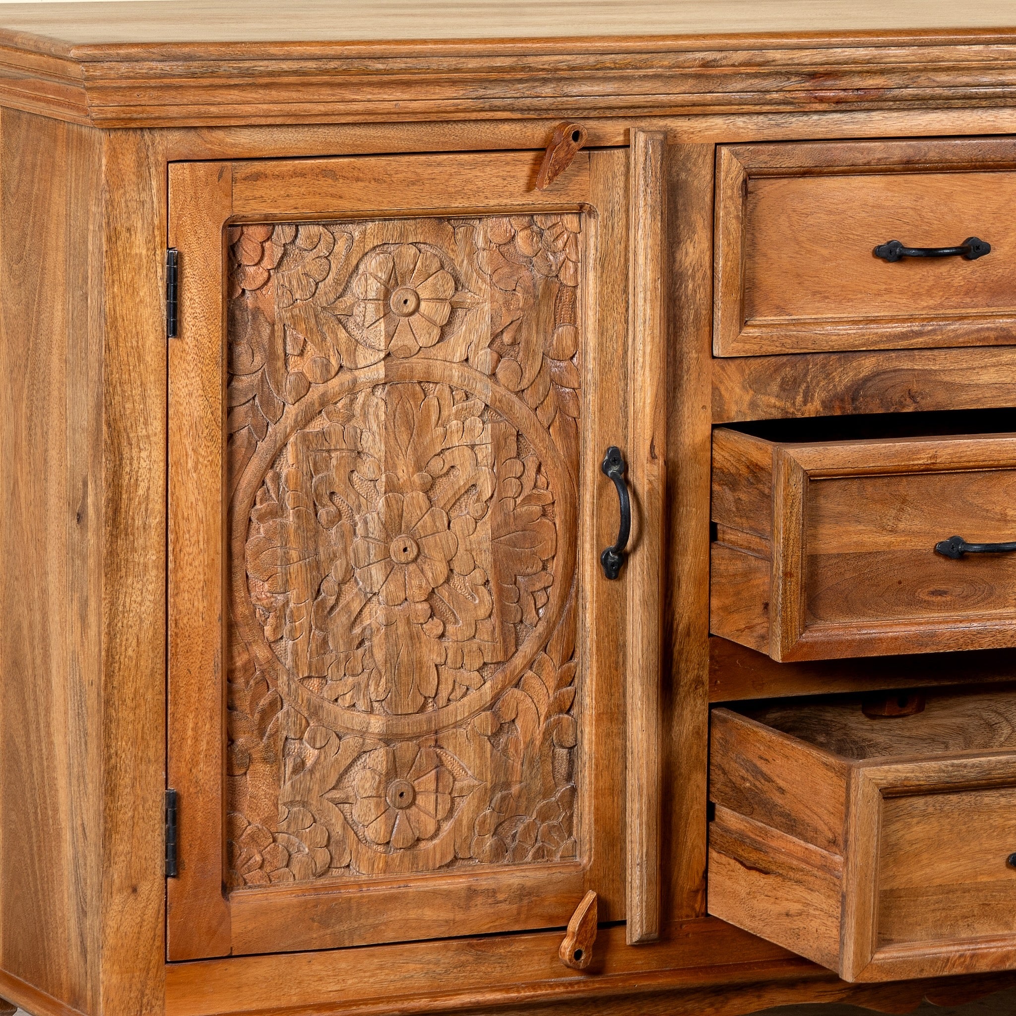 Side angle image with open drawers of a Naren Natural hand carved mango wood sideboard with floral carved doors 150cm
