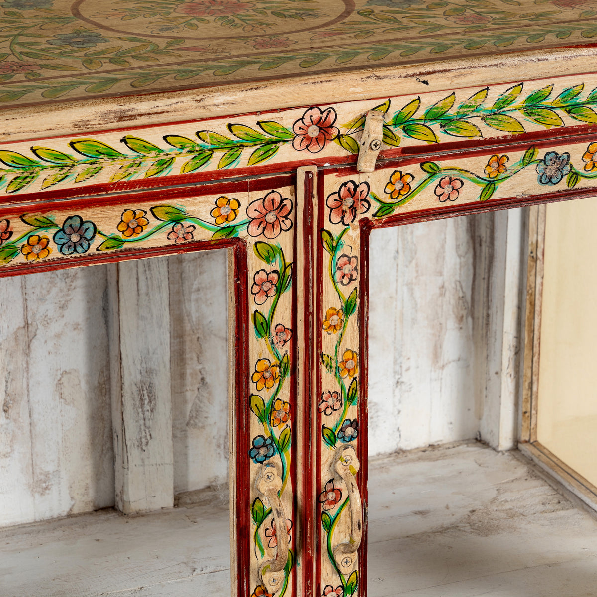 Close up image of a Nikhil hand painted reclaimed wood display cabinet with colourful floral design and four open display sections 120cm