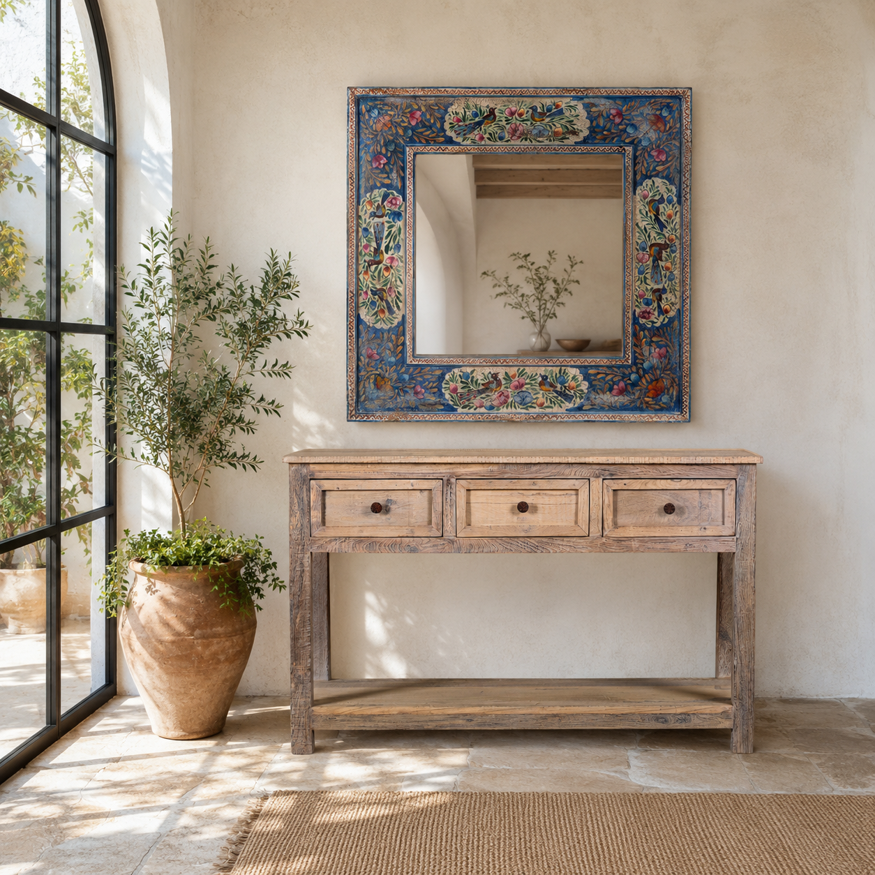 Lifestyle image of a Nithya hand-painted reclaimed wood wall mirror featuring colourful peacocks, birds and floral Indian artwork, 90x90x5cm.