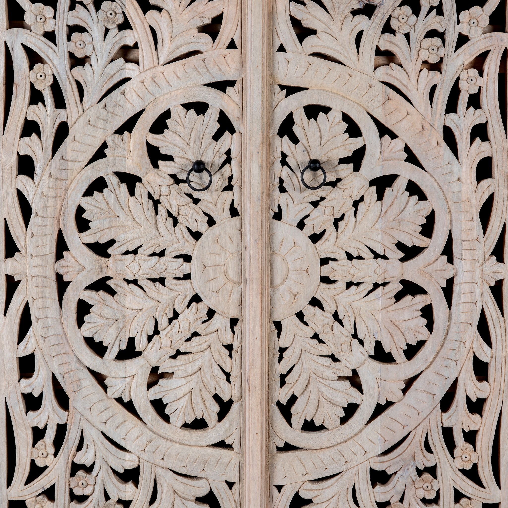 Close up image of a hand-carved mango wood wardrobe, a statement piece of bedroom furniture ideal for a bohemian interior.