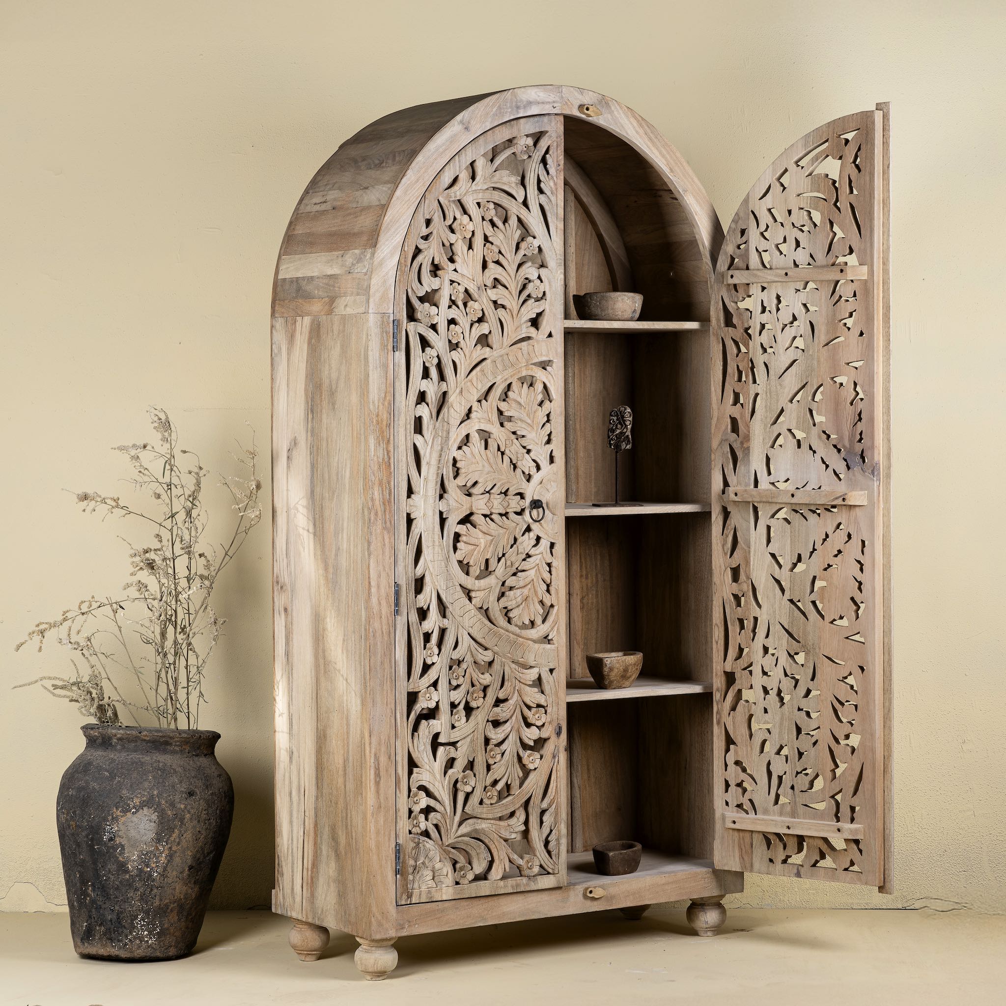 Open door image of a hand-carved mango wood wardrobe, a statement piece of bedroom furniture ideal for a bohemian interior.