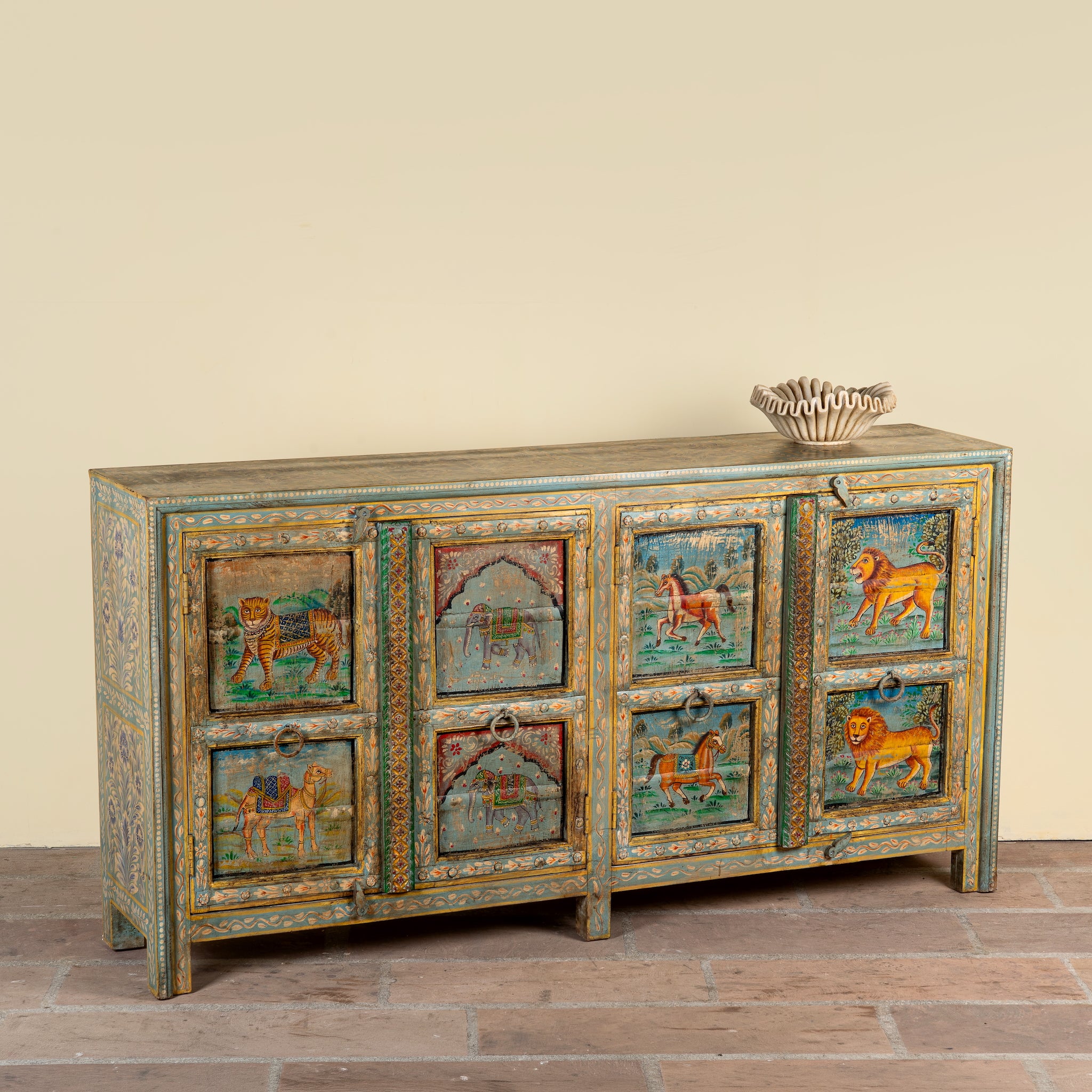 Side angle mage of a Pavan hand-painted reclaimed wood sideboard with original Indian teak doors and colourful tiger, camel, elephant, horse and lion motifs 193cm