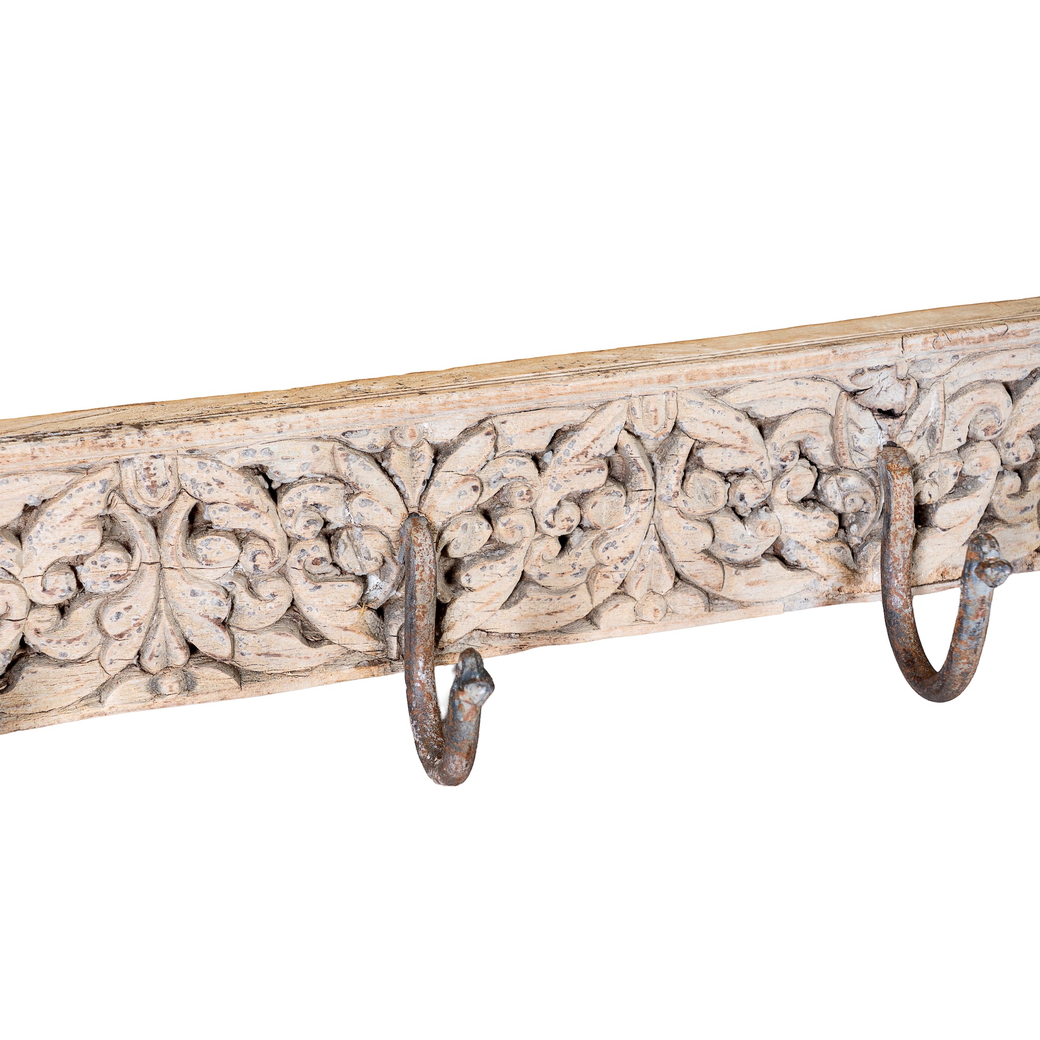 Close up image of a hand-carved reclaimed wood wall hook rack crafted from an antique Indian architectural element with five iron hooks, intricate floral carvings, bleached finish, and vintage rustic character, 150cm.