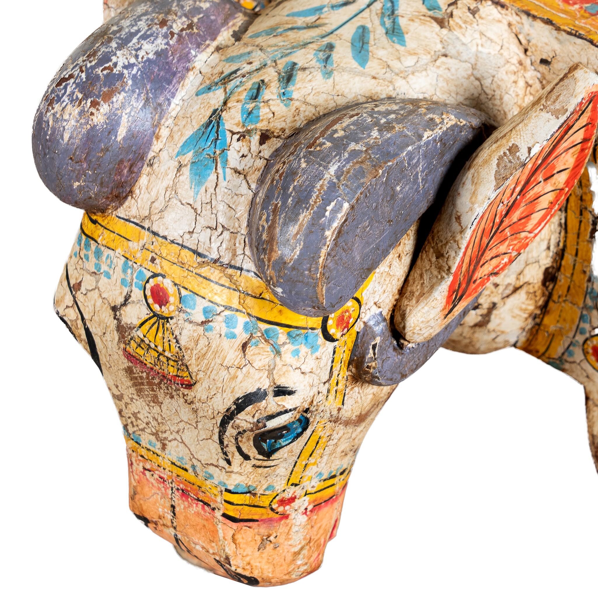 Close up image of a hand-painted wooden side table in the shape of a ram with curved horns, featuring colourful Indian folk art patterns, ideal for vintage and India-inspired home accessories.