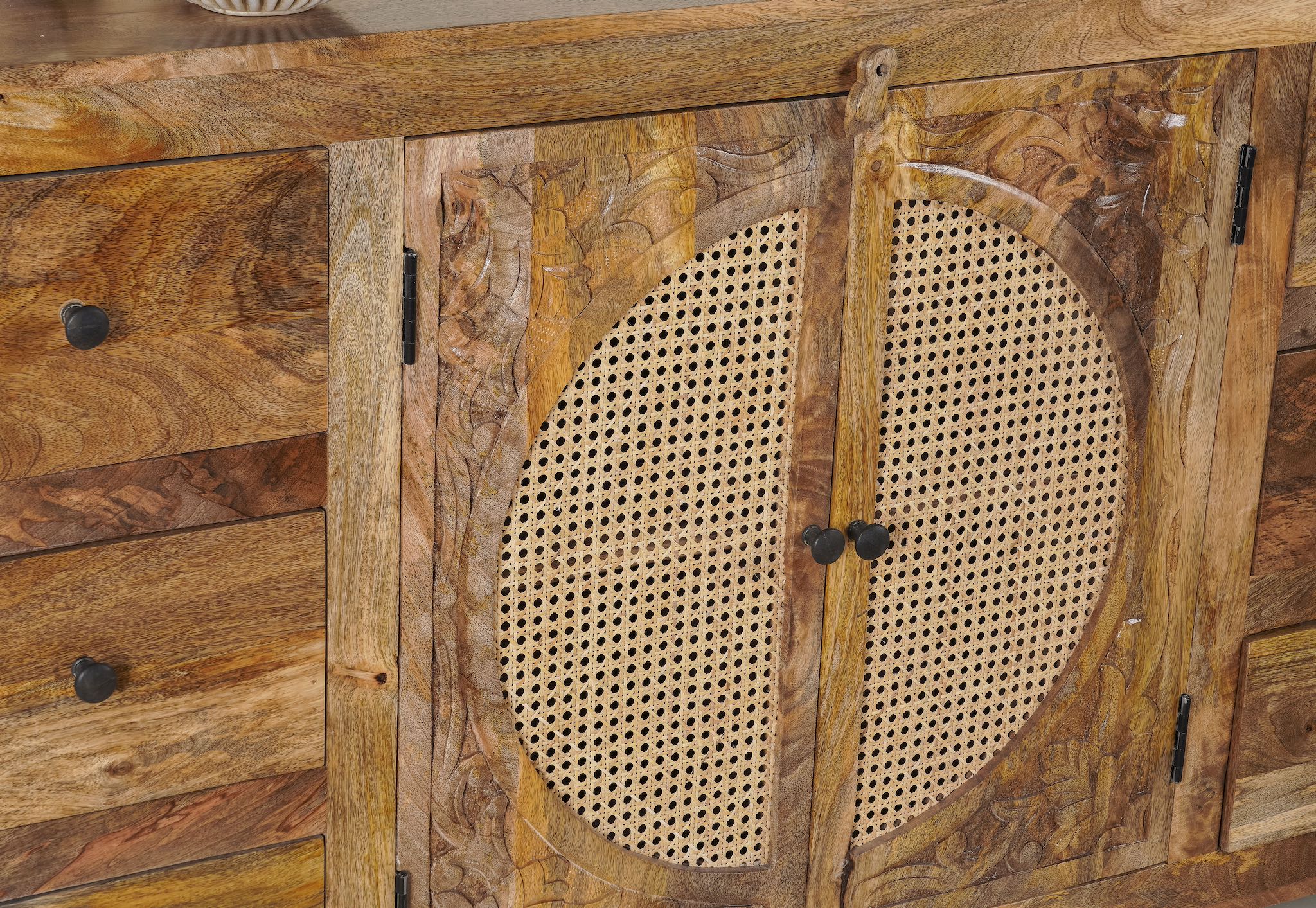 Close up image of a hand-carved wood furniture sideboard with floral motifs and rattan cabinet doors, solid mango wood rattan furniture, 160 × 40 × 90 cm.