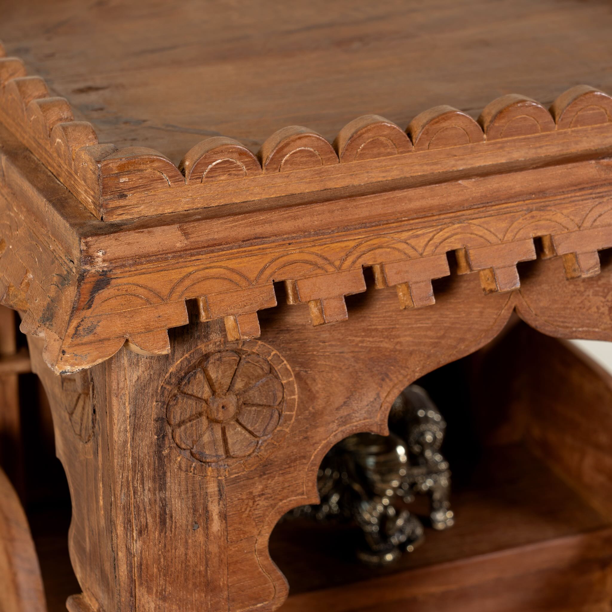 Close up image of a handcrafted old teak wood home temple with carved details and drawer, ideal for religious items and Indian spiritual home accessories.