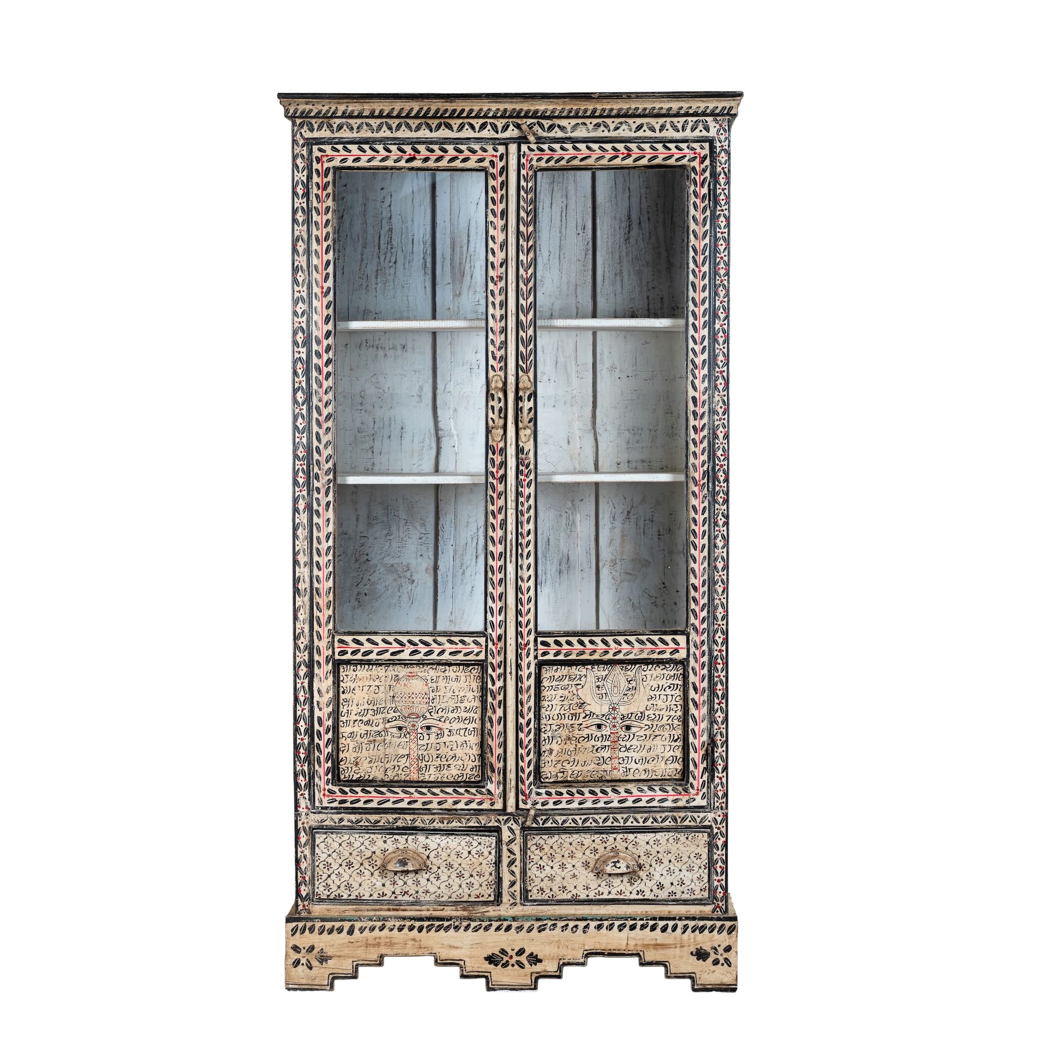 White background image of a hand-painted display cabinet Ritesh made from recycled wood with glass doors – sustainable furniture featuring Sanskrit motifs and traditional Indian craftsmanship.