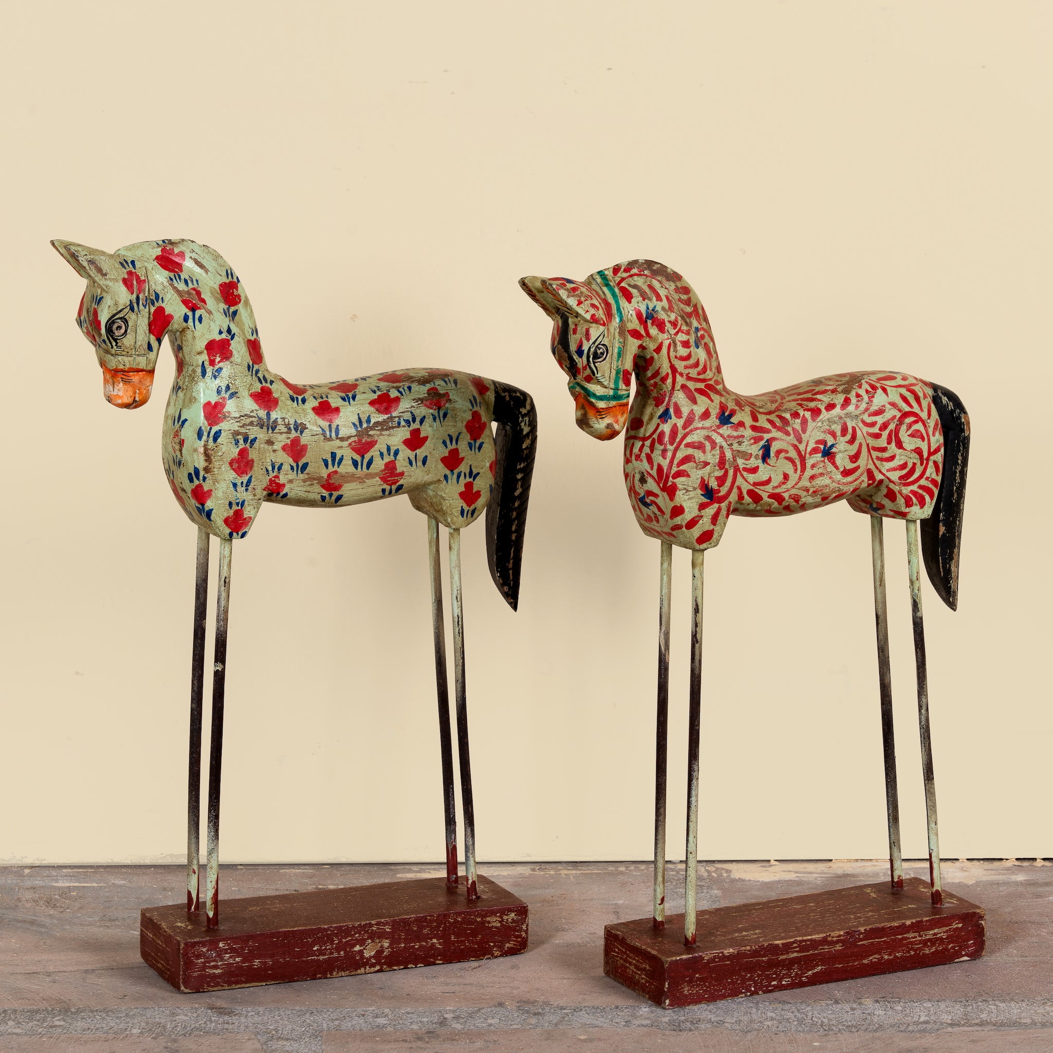 Ritish hand-painted wooden horse sculptures on iron stands in assorted colours and designs. Unique Indian decor items, perfect for bohemian interiors and artisanal furniture displays.