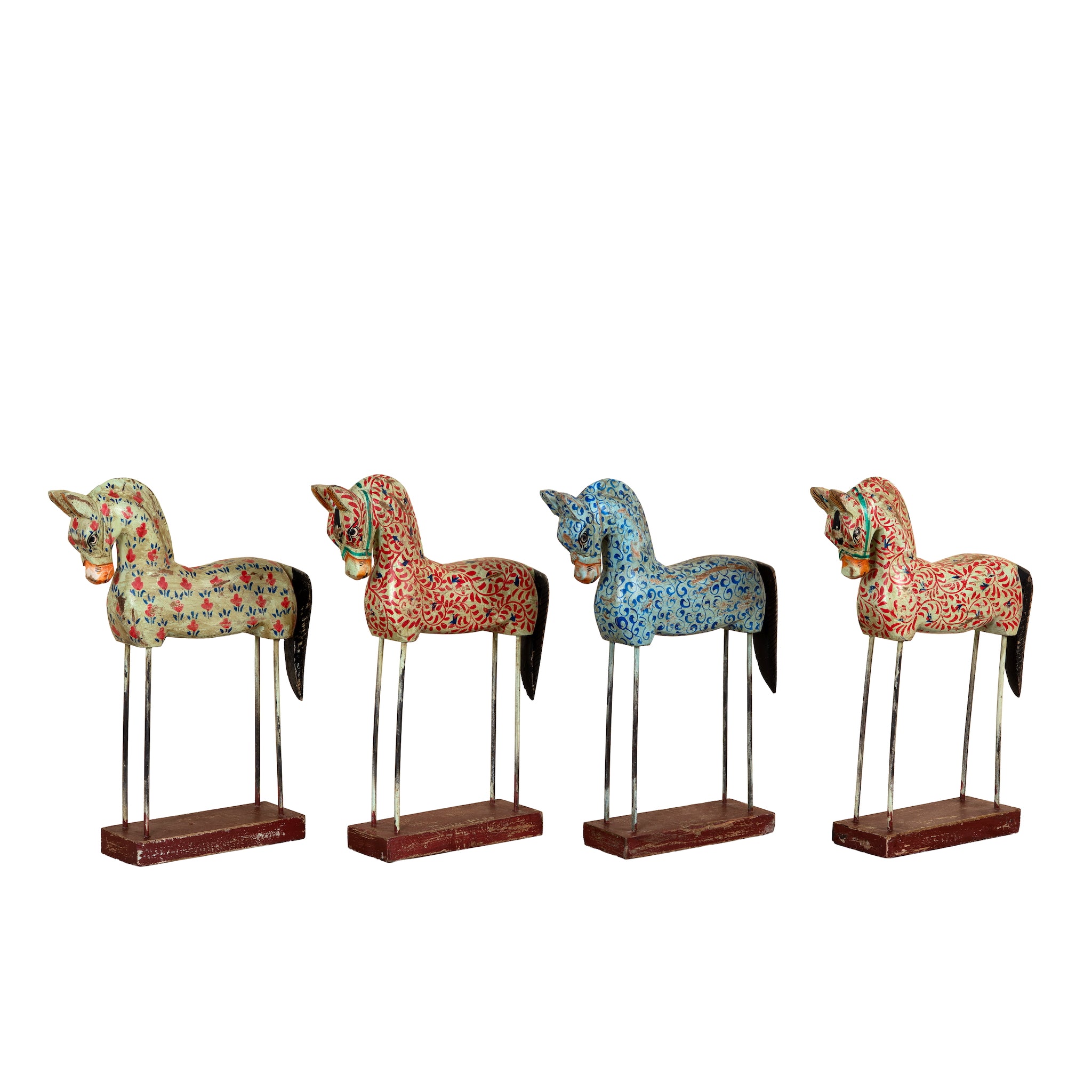 Four decorative horse figurines with intricate floral patterns in red, blue, and green, mounted on metal stands with dark wood bases, set against a plain white background.