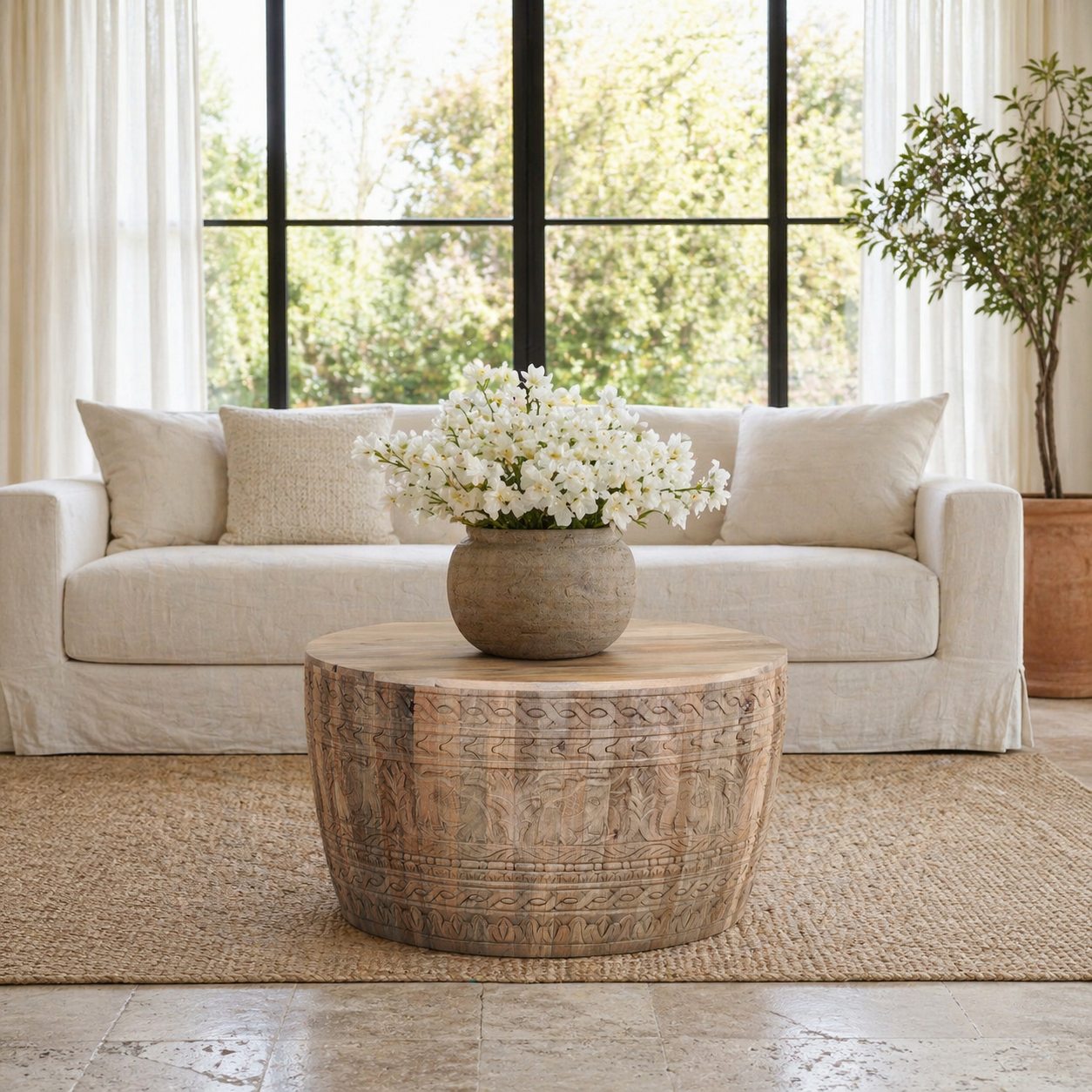 Lifestyle image of a hand-carved mango wood coffee table with intricate botanical and geometric carvings.