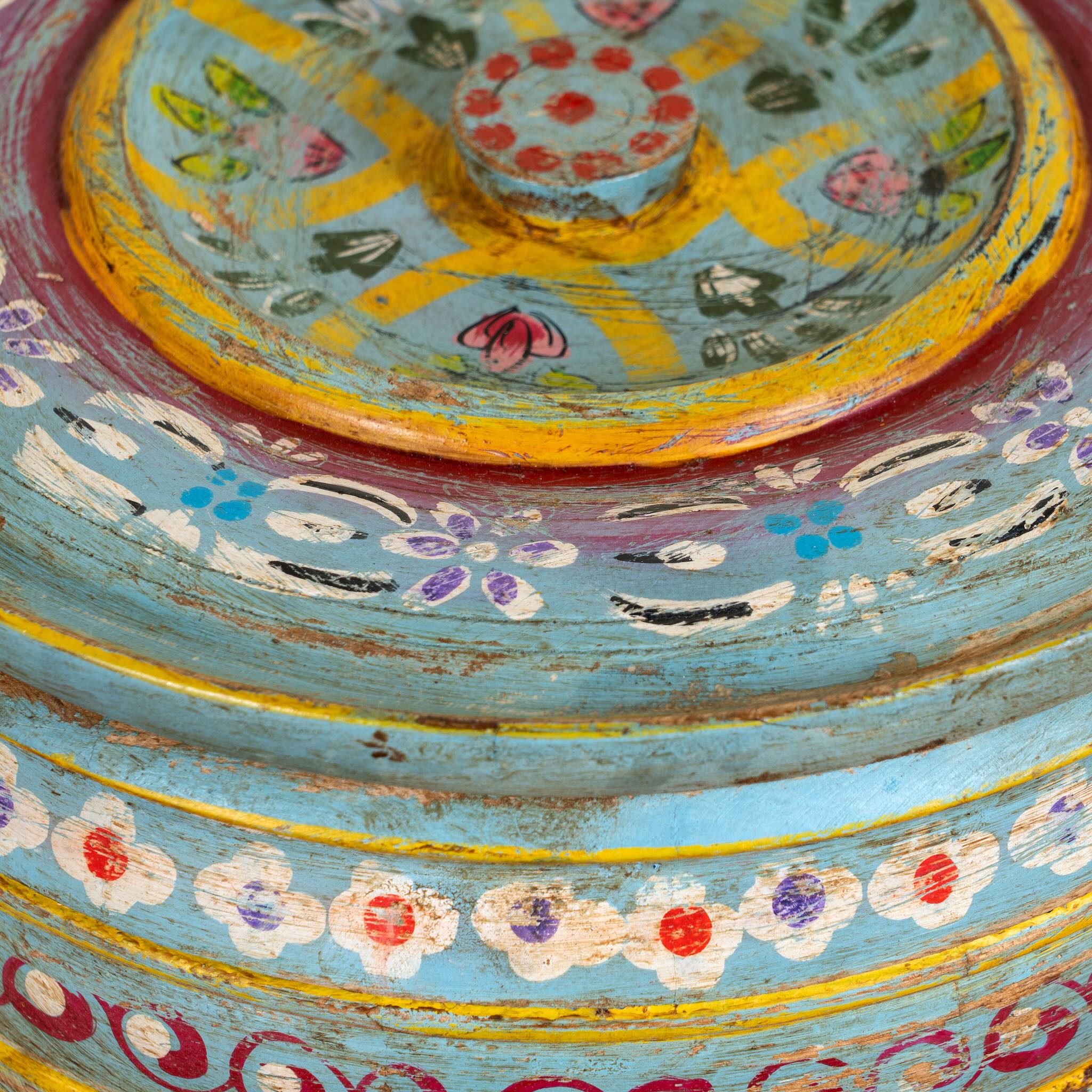 Hand-painted round wooden box with lid, featuring traditional Indian script and decorative motifs in red, blue, and black. A unique Indian decor item used for storage or display, available in four different designs.