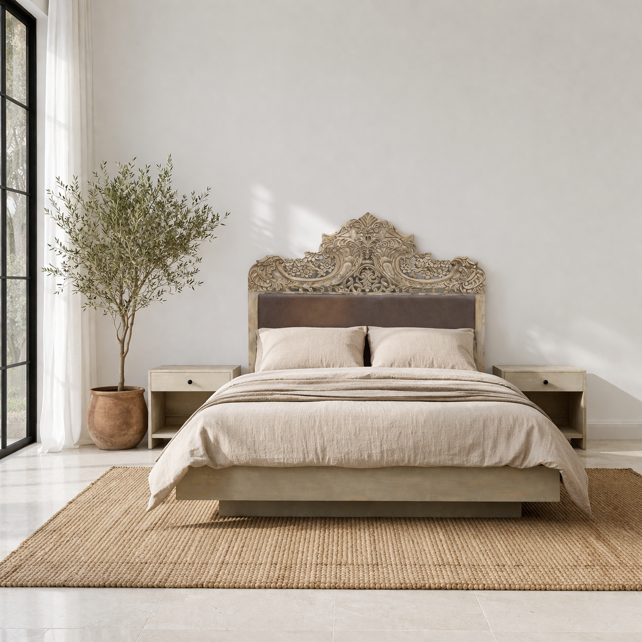 Lifestyle image of a hand-carved vintage bed Samar made from distressed mango wood, featuring an ornate high headboard with soft grey fabric upholstery. A unique blend of Indian craftsmanship and contemporary comfort in a natural, neutral palette.