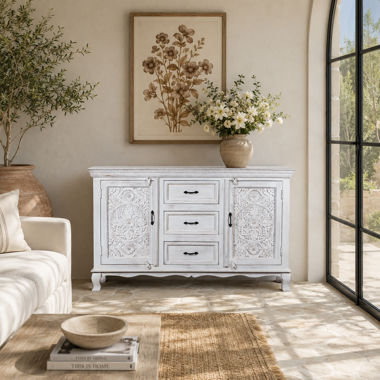 Lifestyle image of a mediterranean-style carved sideboard in solid mango wood with floral motifs and elegant legs; ideal for vintage home decor, 150 × 90 × 40 cm.