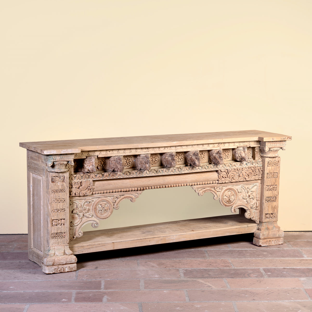 Side angle image of a Sayon large carved reclaimed teak console table with antique Indian house elements and lower shelf, 216x54x92cm