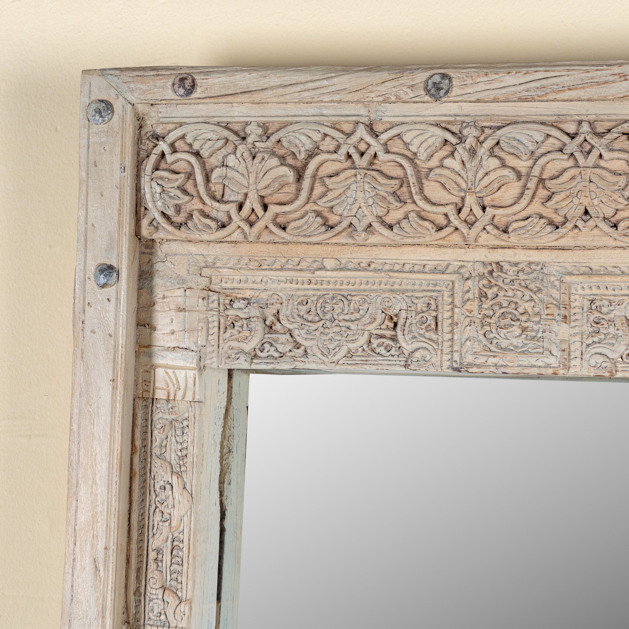 Close up image of a Serena antique reclaimed teak wood wall mirror made from an original teak window frame with hand-carved details, bleached finish, 98x13x165cm.