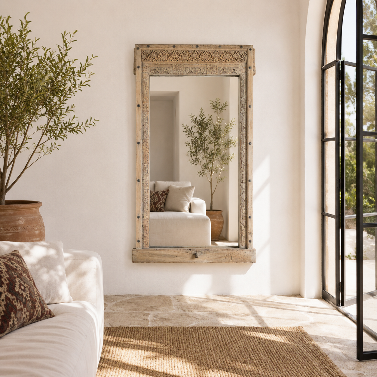 Lifestyle image of a Serena antique reclaimed teak wood wall mirror made from an original teak window frame with hand-carved details, bleached finish, 98x13x165cm.