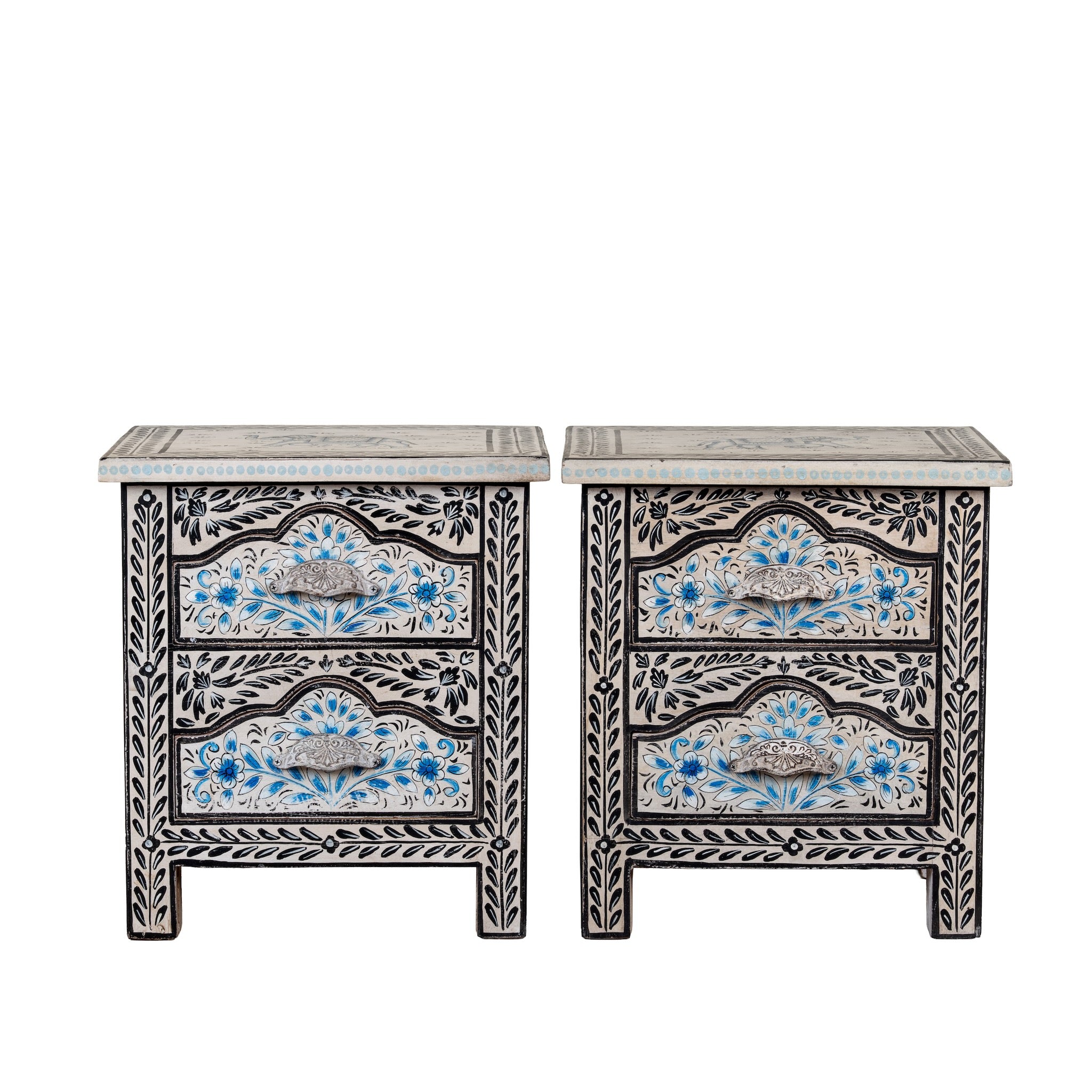 White background picture of a pair of hand-painted nightstands made from reclaimed wood, featuring floral motifs in soft turquoise and black with intricate carved detailing and two drawers for storage.