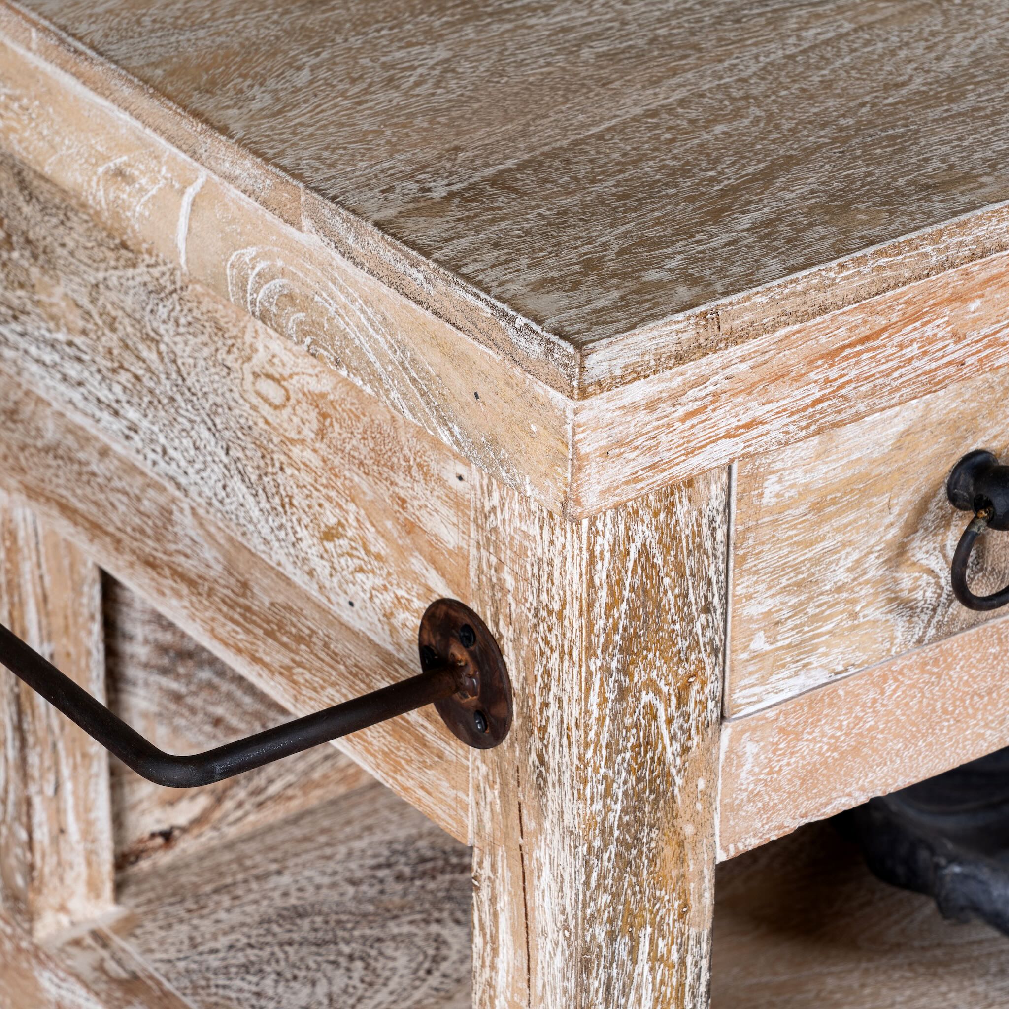Close up image of a white washed mango wood console table with 4 drawers and shelves. Solid wood counter table with rustic vintage look and storage.