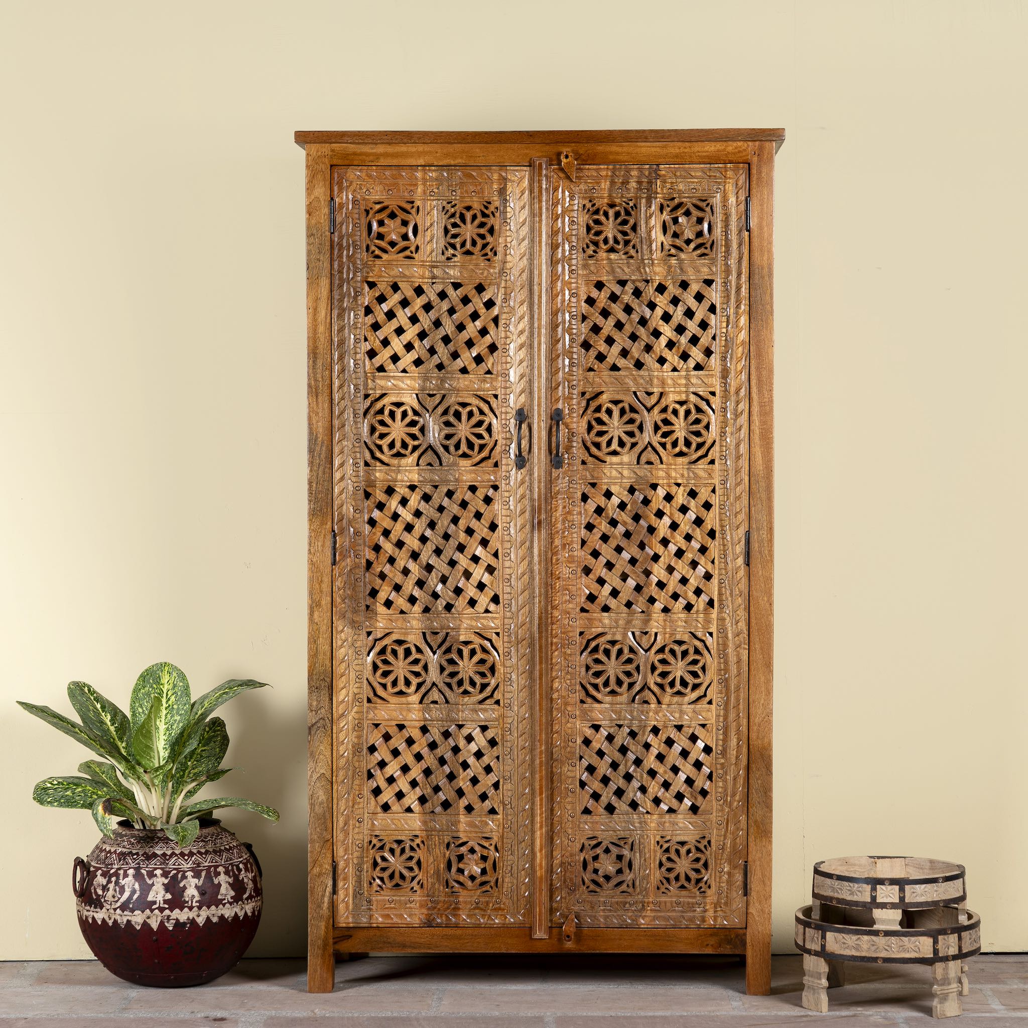 Hand-carved mango wood wardrobe with floral and lattice motifs – a detailed piece of carved wood furniture ideal for natural mango wood interiors.