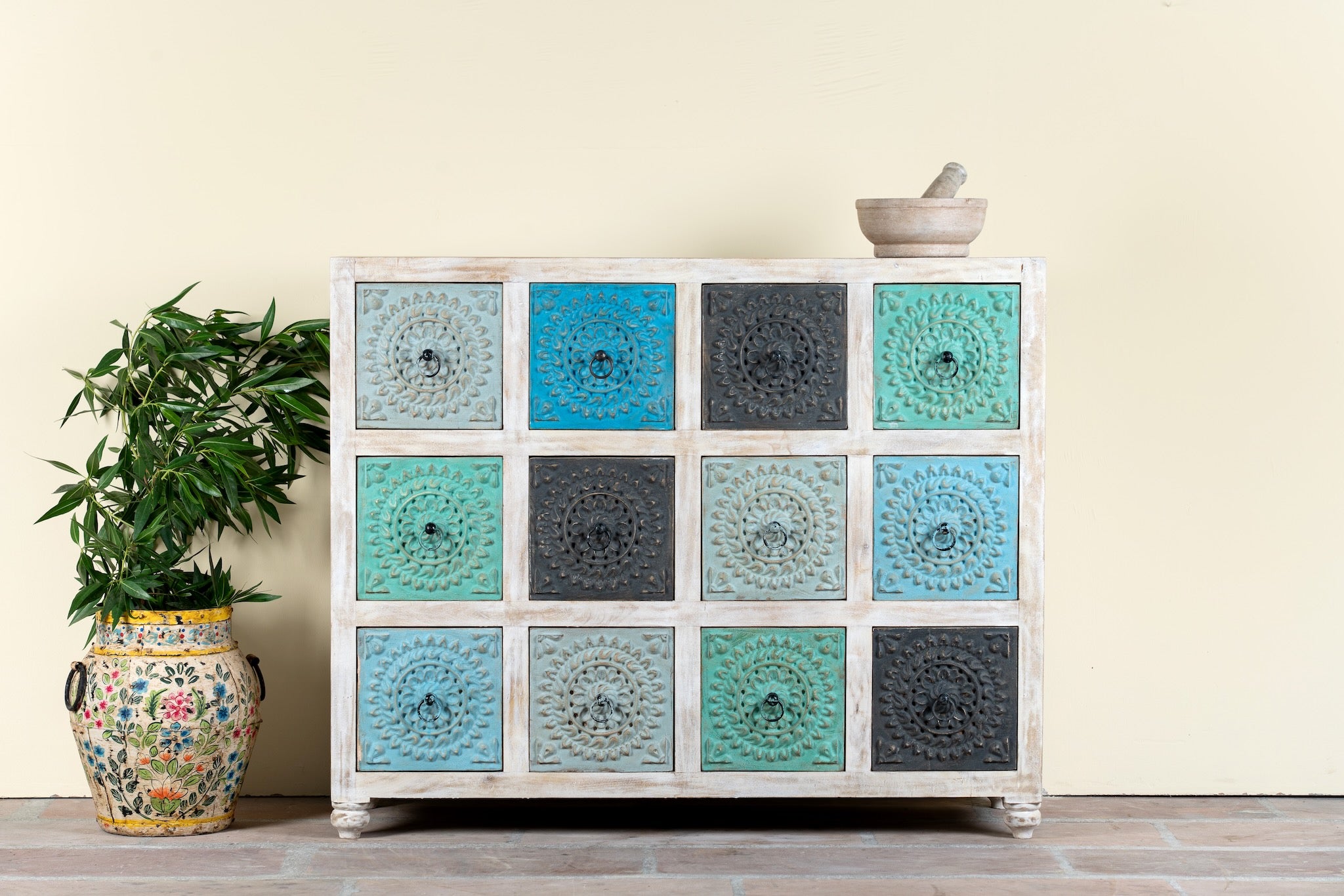 Image of a carved mango wood chest of drawers with twelve multicolour floral drawer fronts, 124 × 40 × 102 cm.