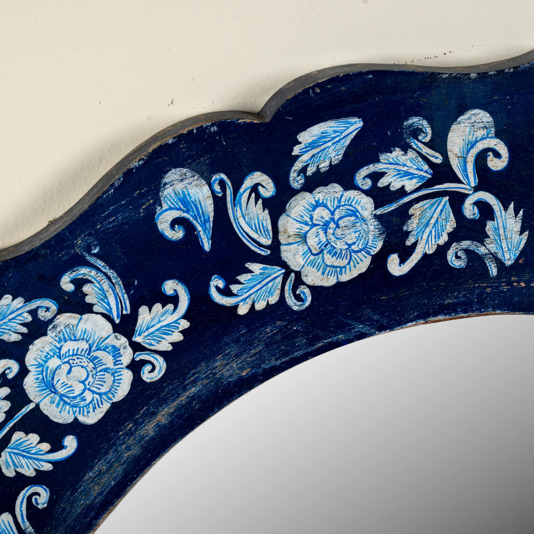 Close up image of a Uttam hand-painted round reclaimed wood mirror with deep blue floral frame, vintage artisan detailing, 90cm diameter.