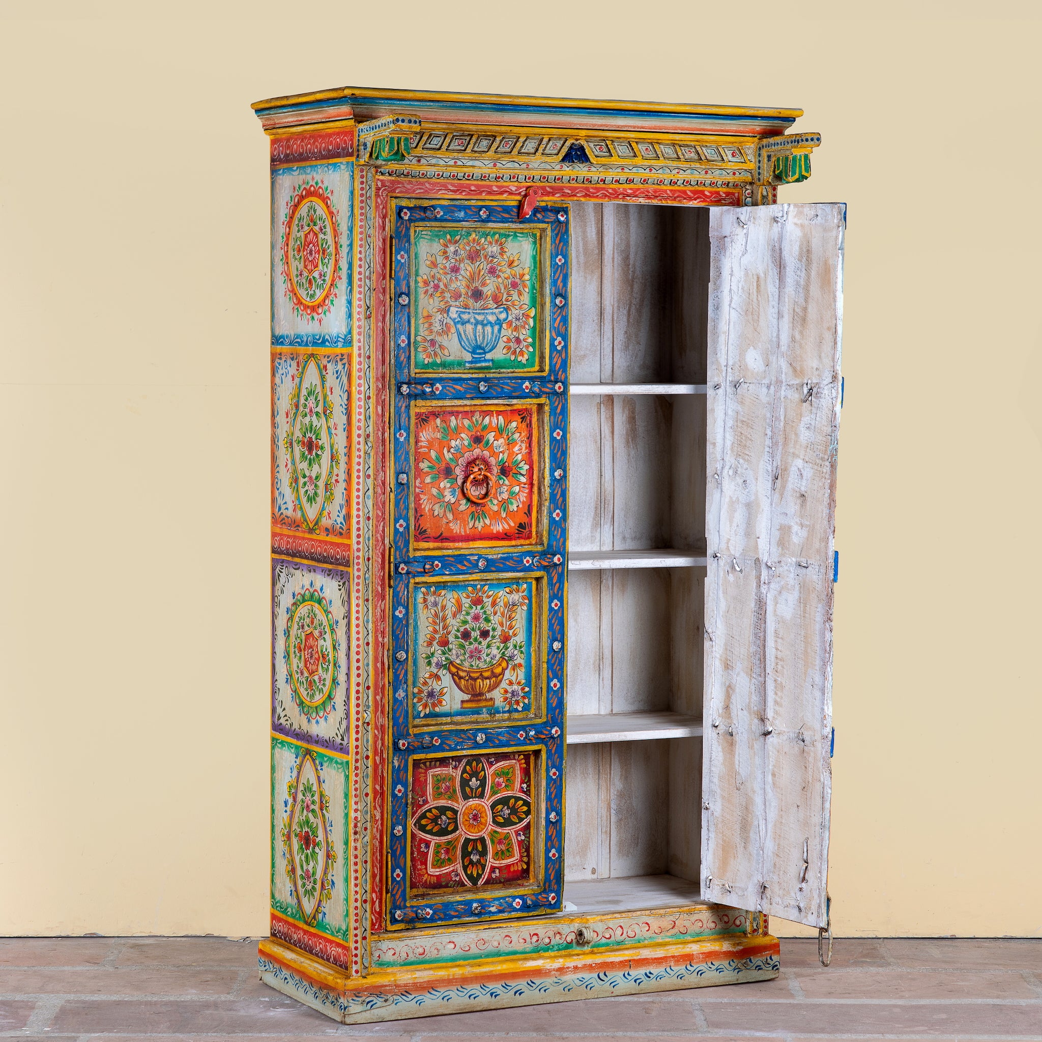 Side angle with open door image of a hand-painted teak wood cabinet with floral motifs; teak wood furniture for bohemian interiors, 105 × 55 × 177 cm.