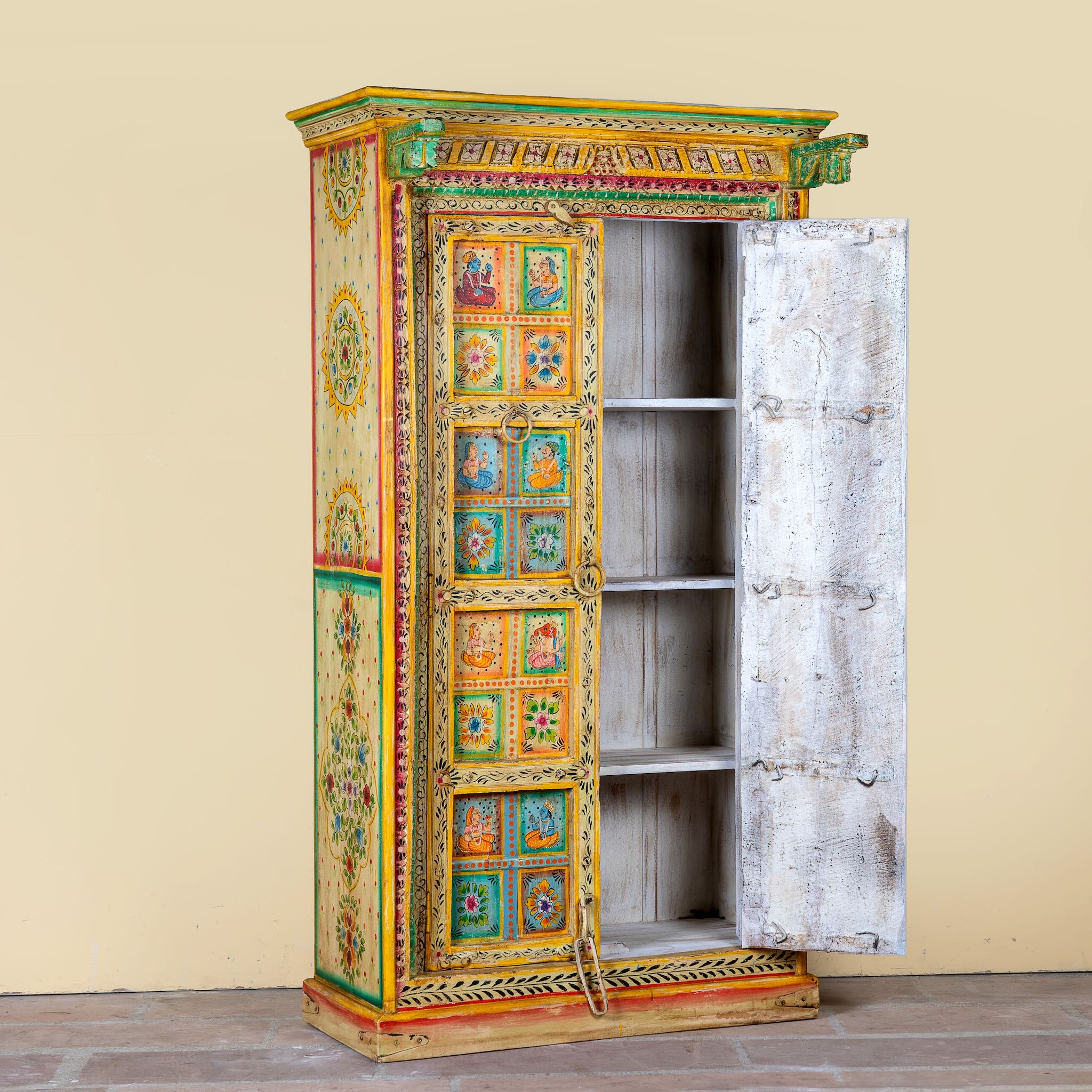 Open door image of a hand painted wardrobe made of teak wood with floral motifs; unique furniture inspired by Indian artistry, 104 × 50 × 186 cm.