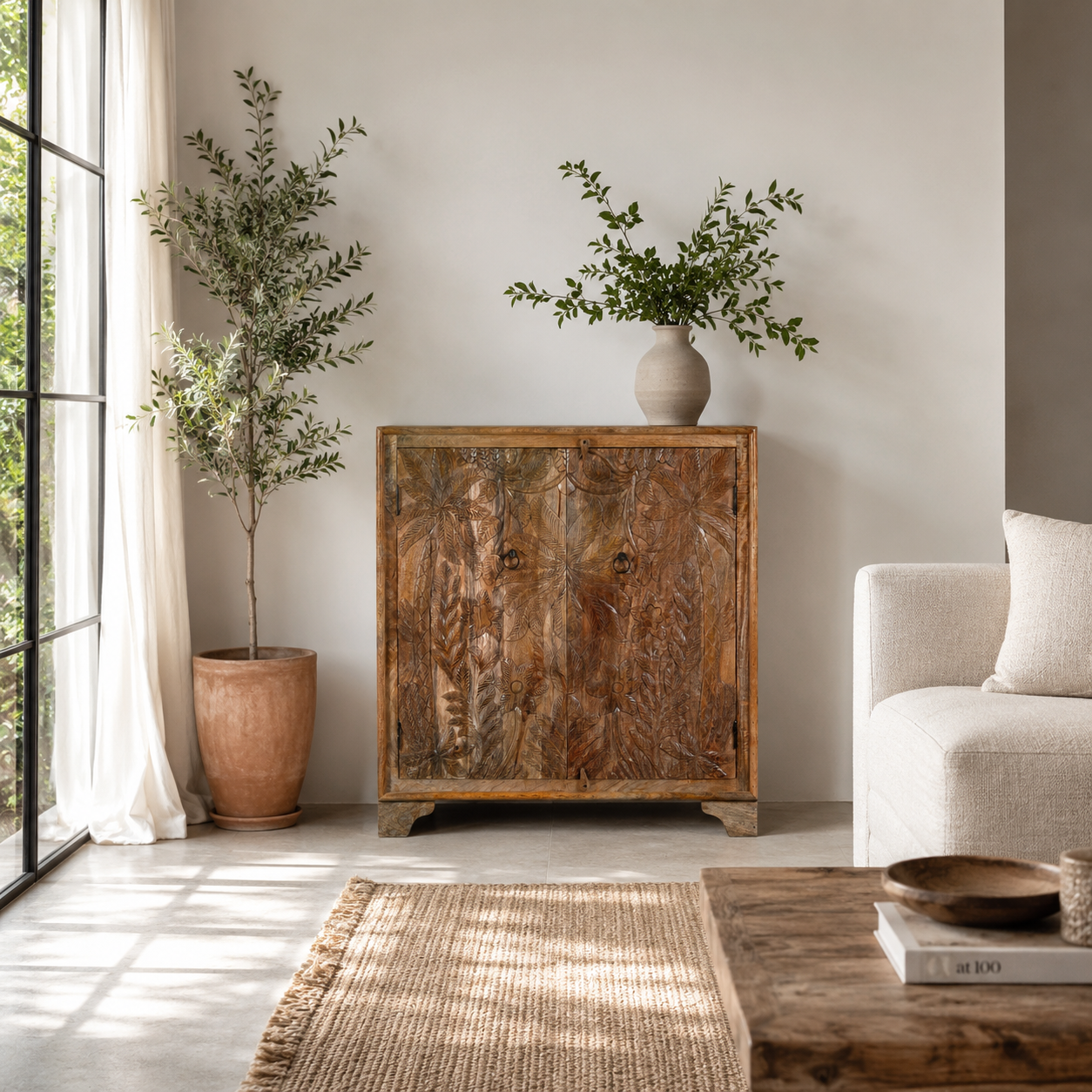 Lifestyle image of a hand-carved mango wood cupboard Vansh with double doors featuring intricate floral and botanical motifs. A Mediterranean-inspired piece of Indian furniture offering functional storage and timeless artisan detail.