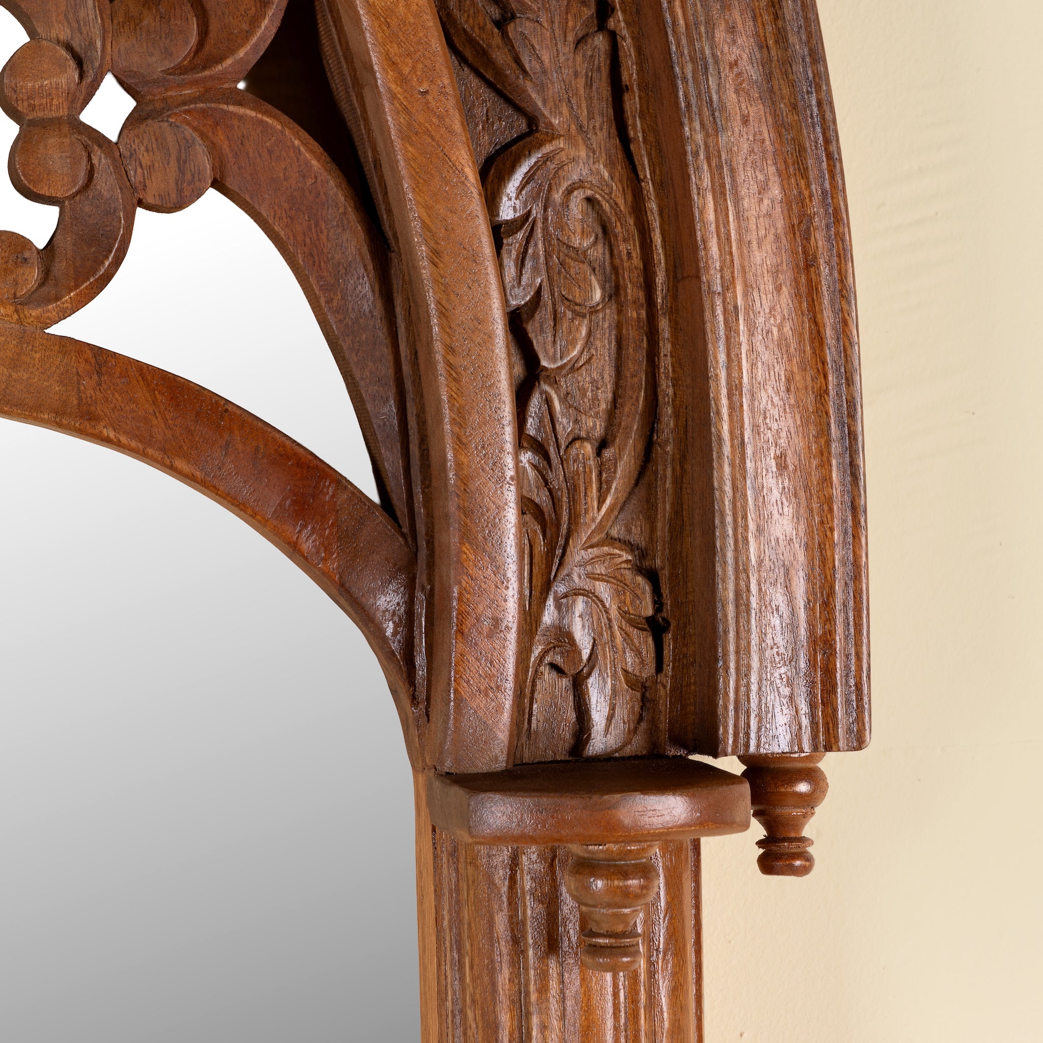 Close up image of a Veeksha hand carved mango wood arch mirror with decorative openwork frame in teak wood finish, 85x15x197cm