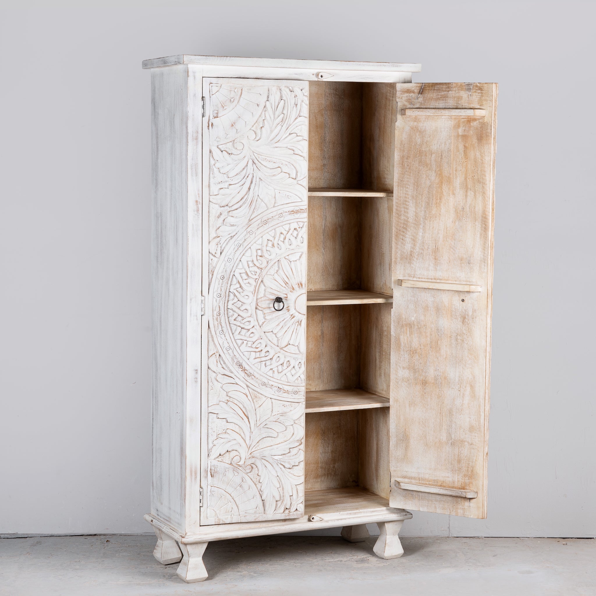 Image showing open door of an Aila handcrafted solid mango wood wardrobe with intricately hand-carved Indian doors, four spacious storage compartments, natural wood grain, and Mediterranean-inspired design, 180cm.