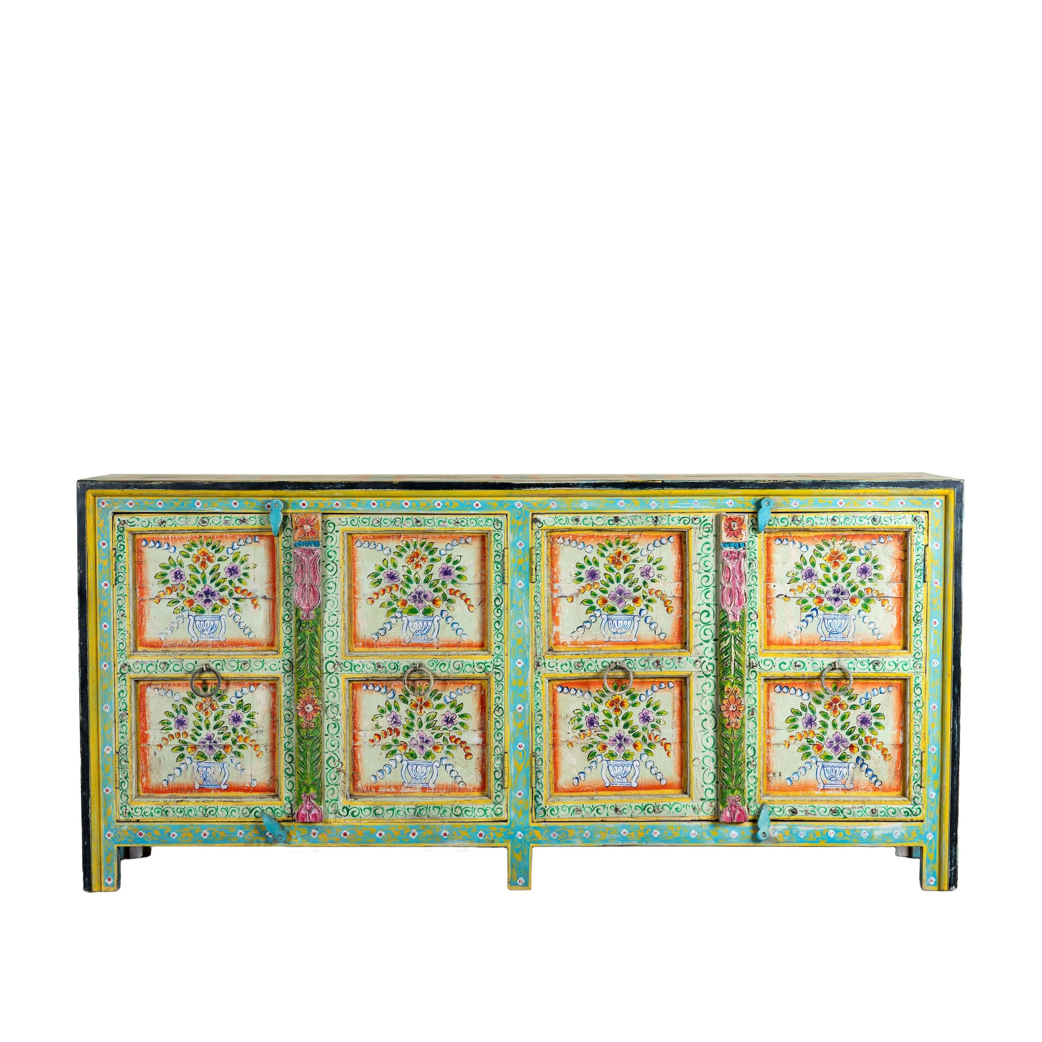 White background image of a reclaimed wood sideboard with hand painted floral motifs and distressed finish; artisanal storage furniture for bohemian interiors, 170 × 40 × 104 cm.
