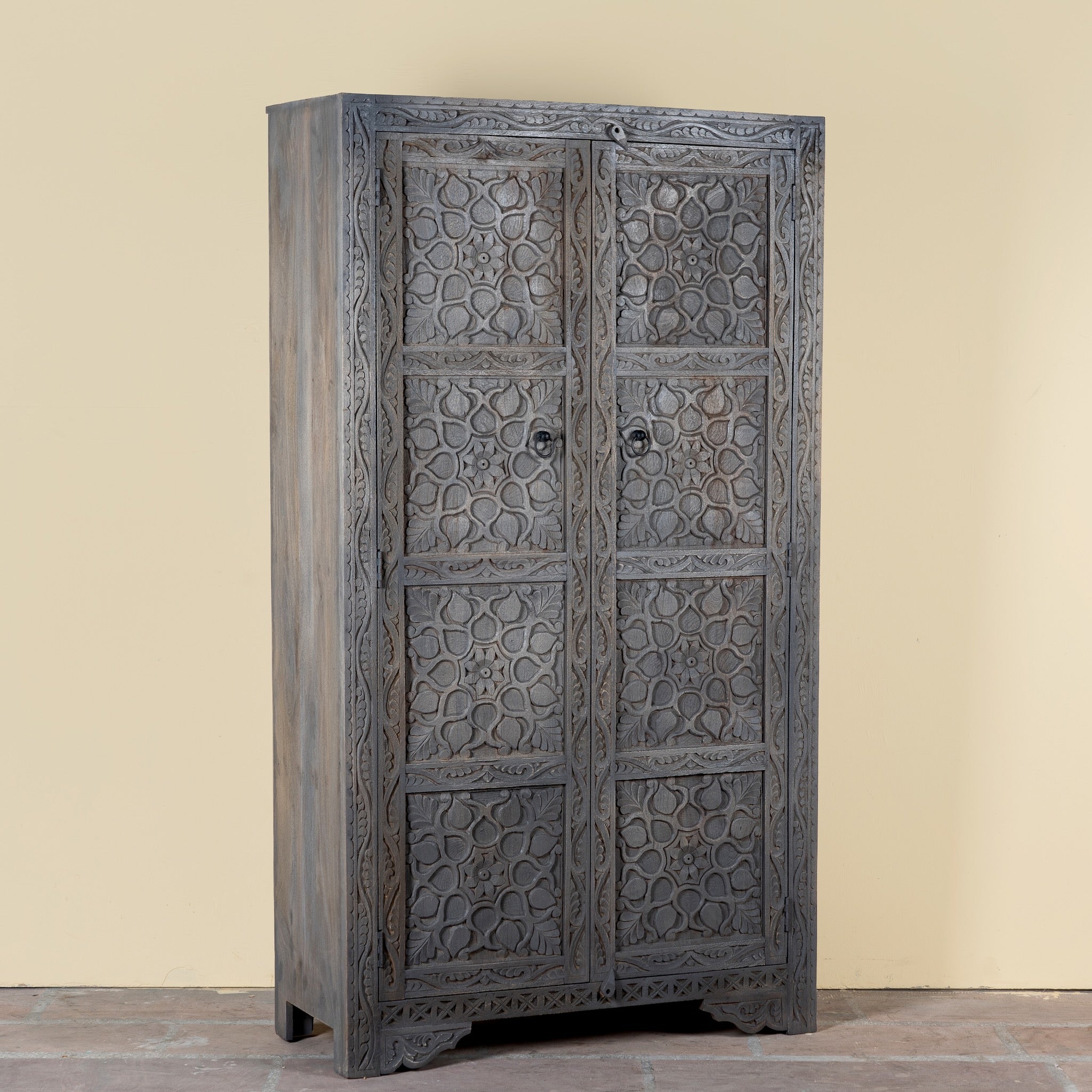 Side angle image of a Vishyali hand carved grey mango wood wardrobe with geometric carved doors 180cm