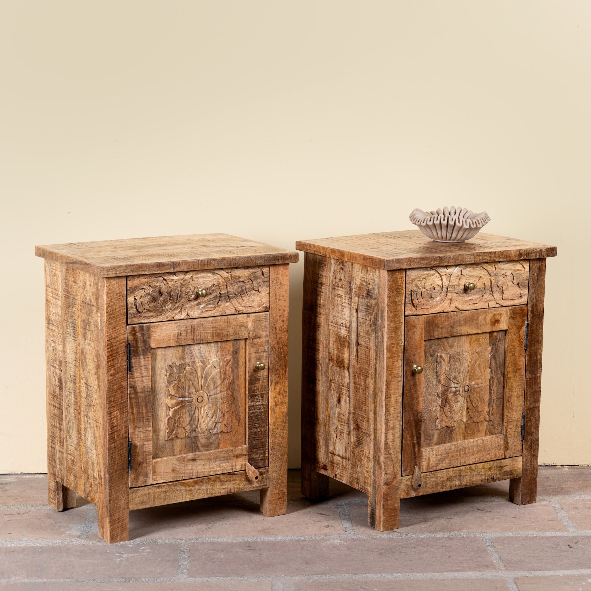 Side angle image of a Yana set of two hand carved mango wood bedside tables with drawer and cupboard 65cm