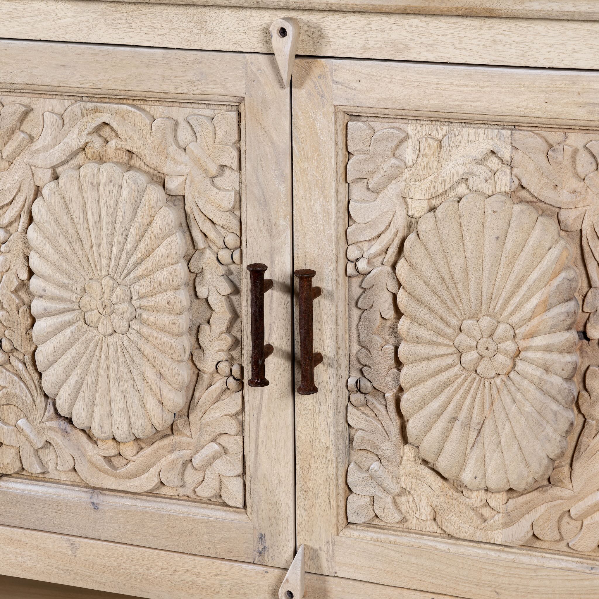 Close up image of a hand-carved mango wood console table Zahira with 2 drawers and 4 doors in a natural finish. Elegant living room furniture piece with artistic detailing and practical storage.