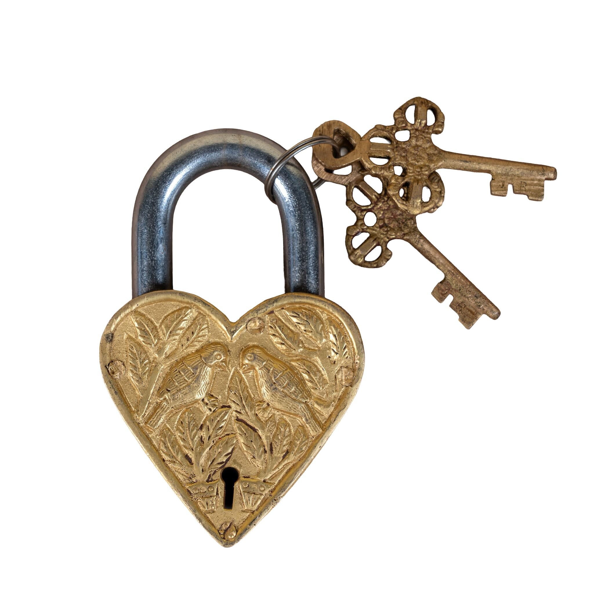 Handcrafted heart-shaped brass lock with engraved details and keys, a decorative brass accessory inspired by traditional Indian home accessories.