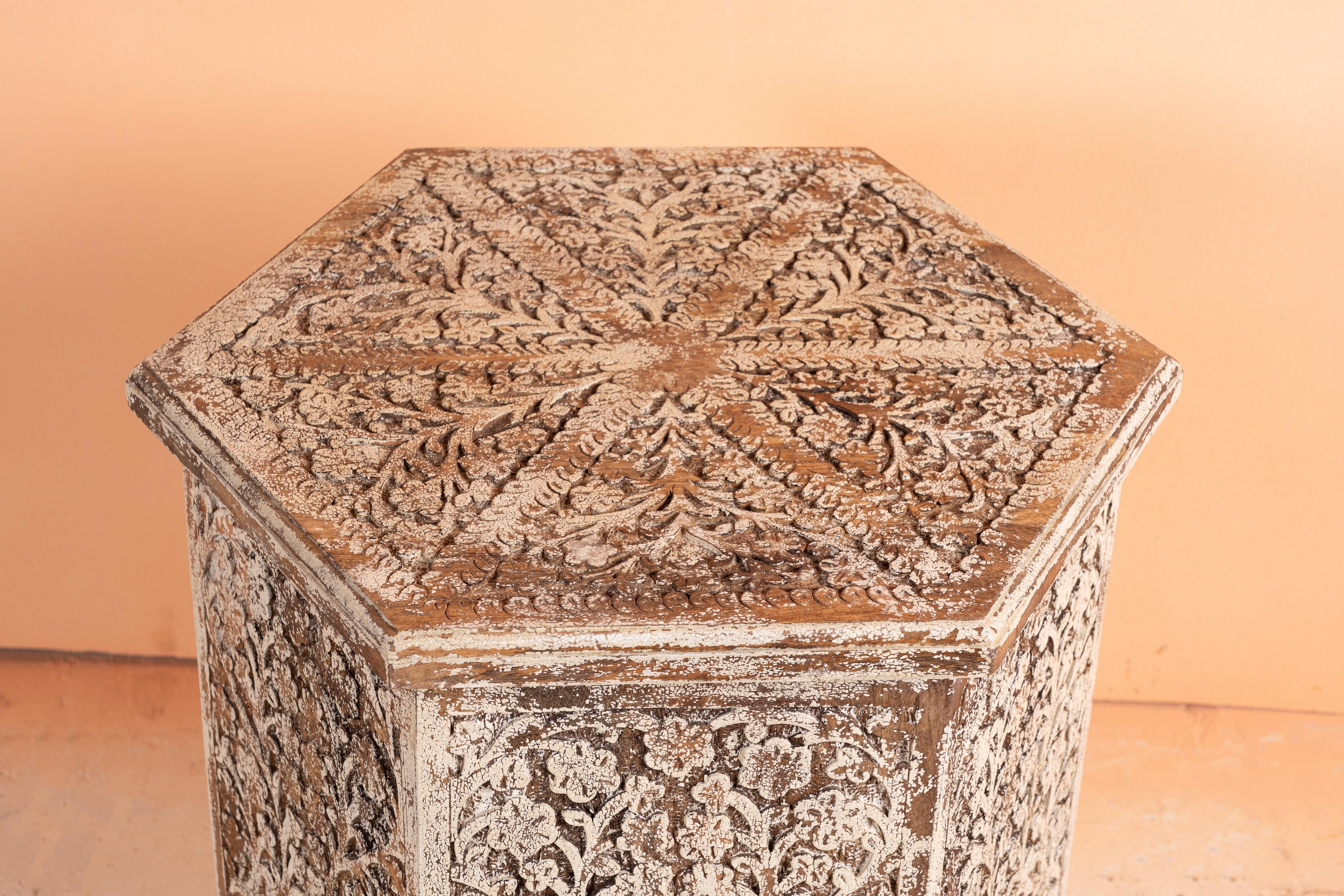 Close up image of the top of a Amreli antique white coffee table made of mango wood, hand carved.