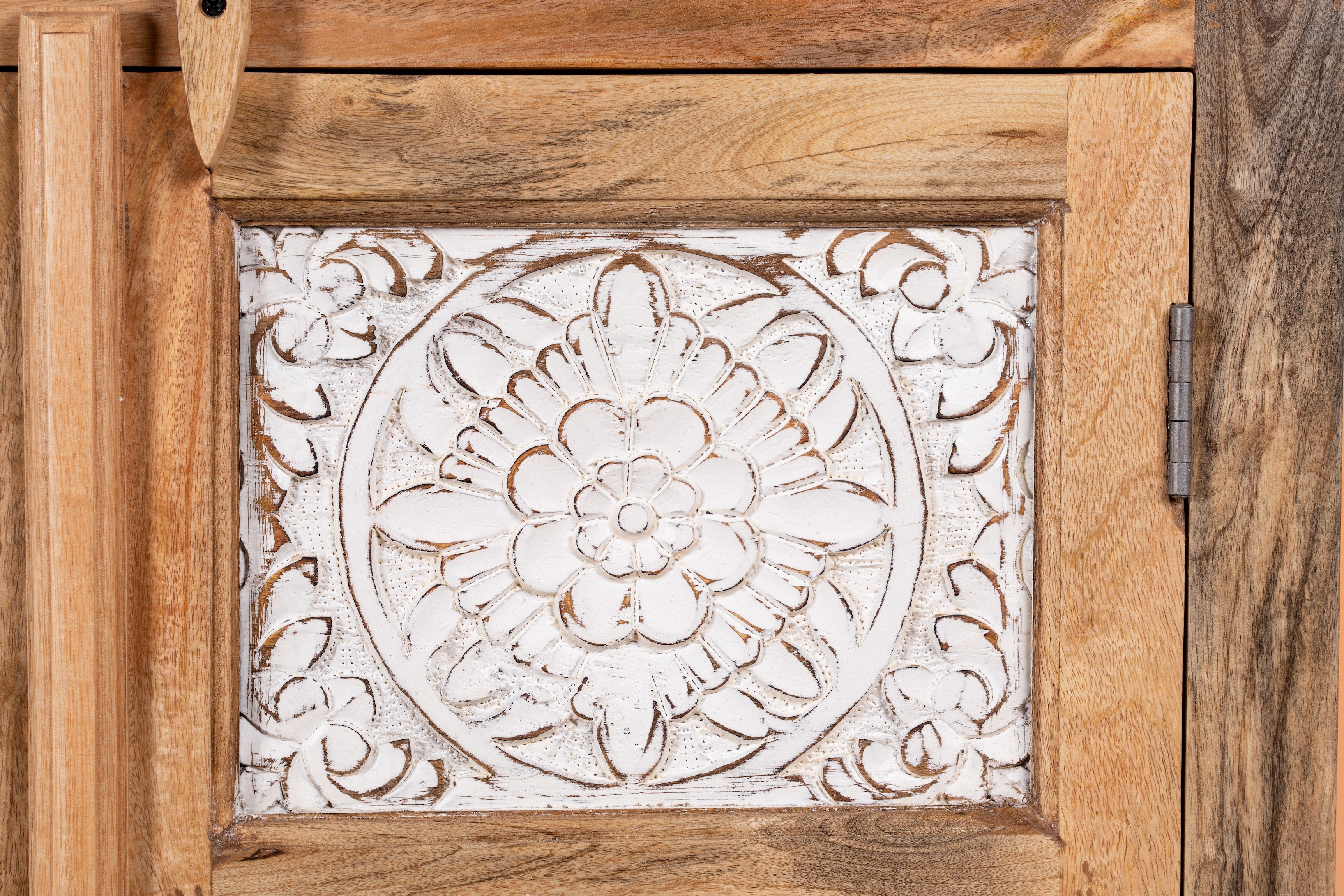 Close up image of a carved sideboard / bedroom furniture in mango wood with white-washed floral engravings, 90 × 40 × 100 cm.