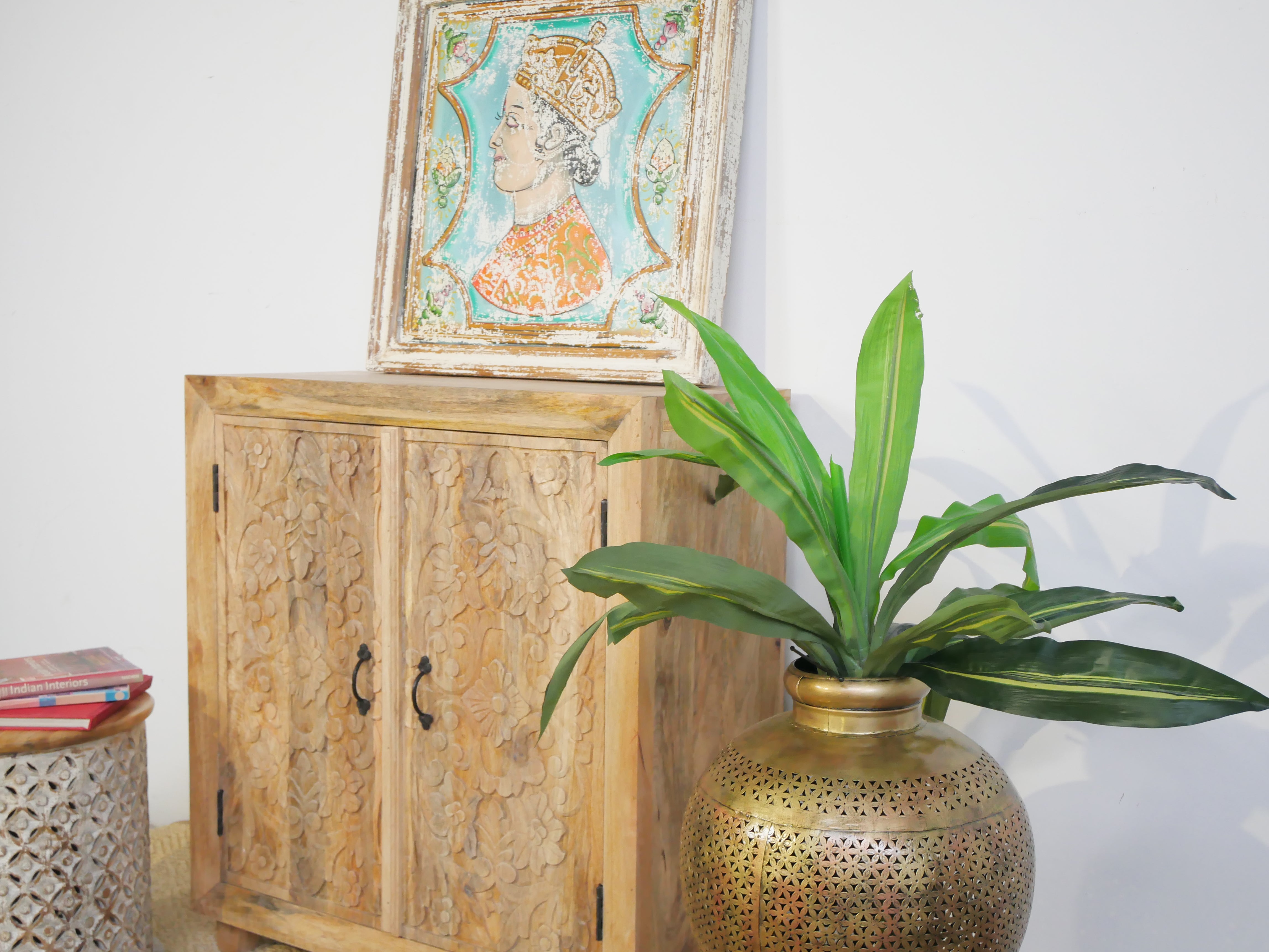 Side angle image of a carved wood furniture cabinet made from solid mango wood, hand-carved floral design, Mediterranean-style, 90 × 97 × 40 cm.