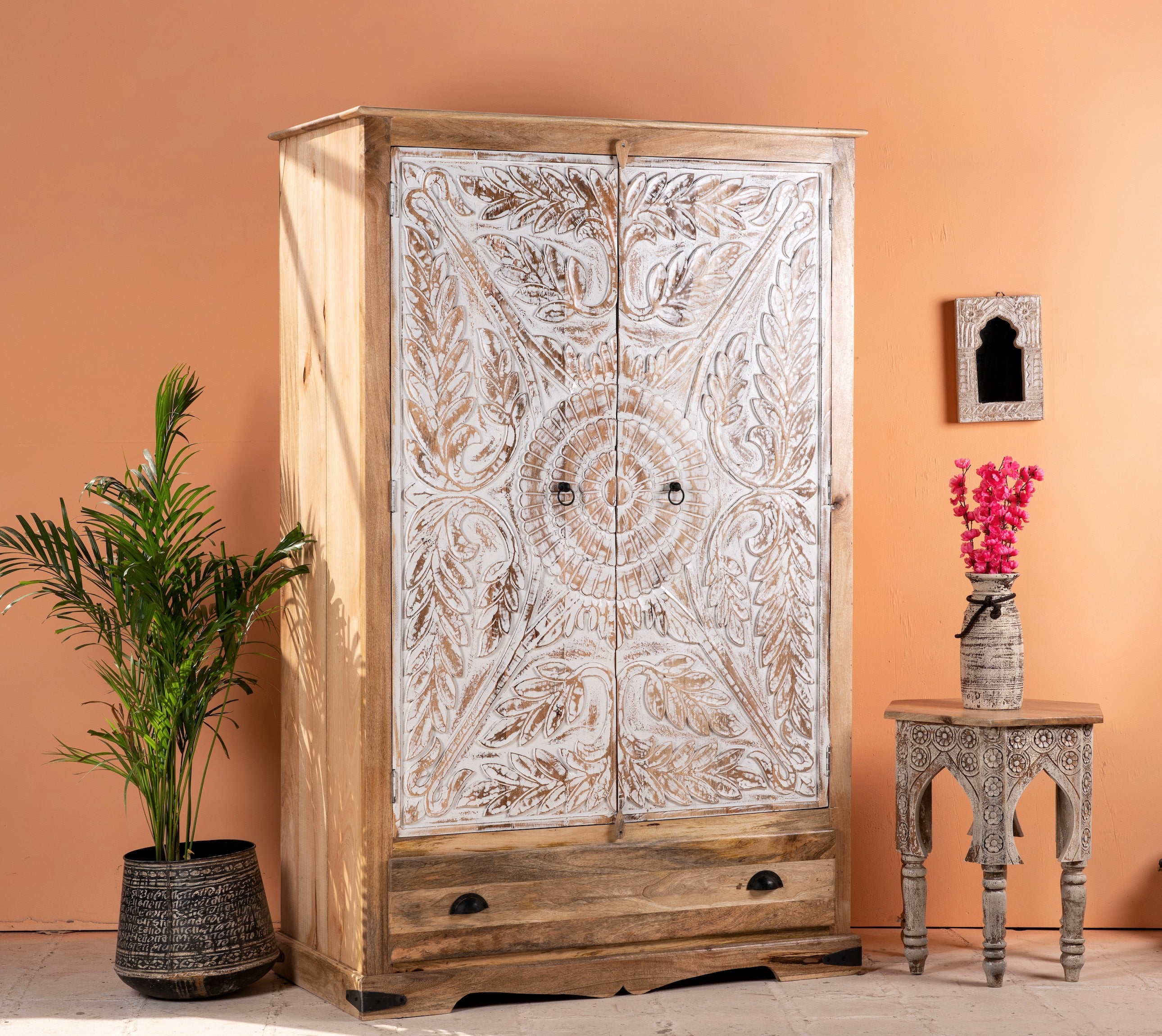 side angle image of a Cheyyur handcrafted solid mango wood wardrobe with hand-carved whitewashed doors, large storage drawer, traditional Indian detailing, and natural wood grain, 190cm.