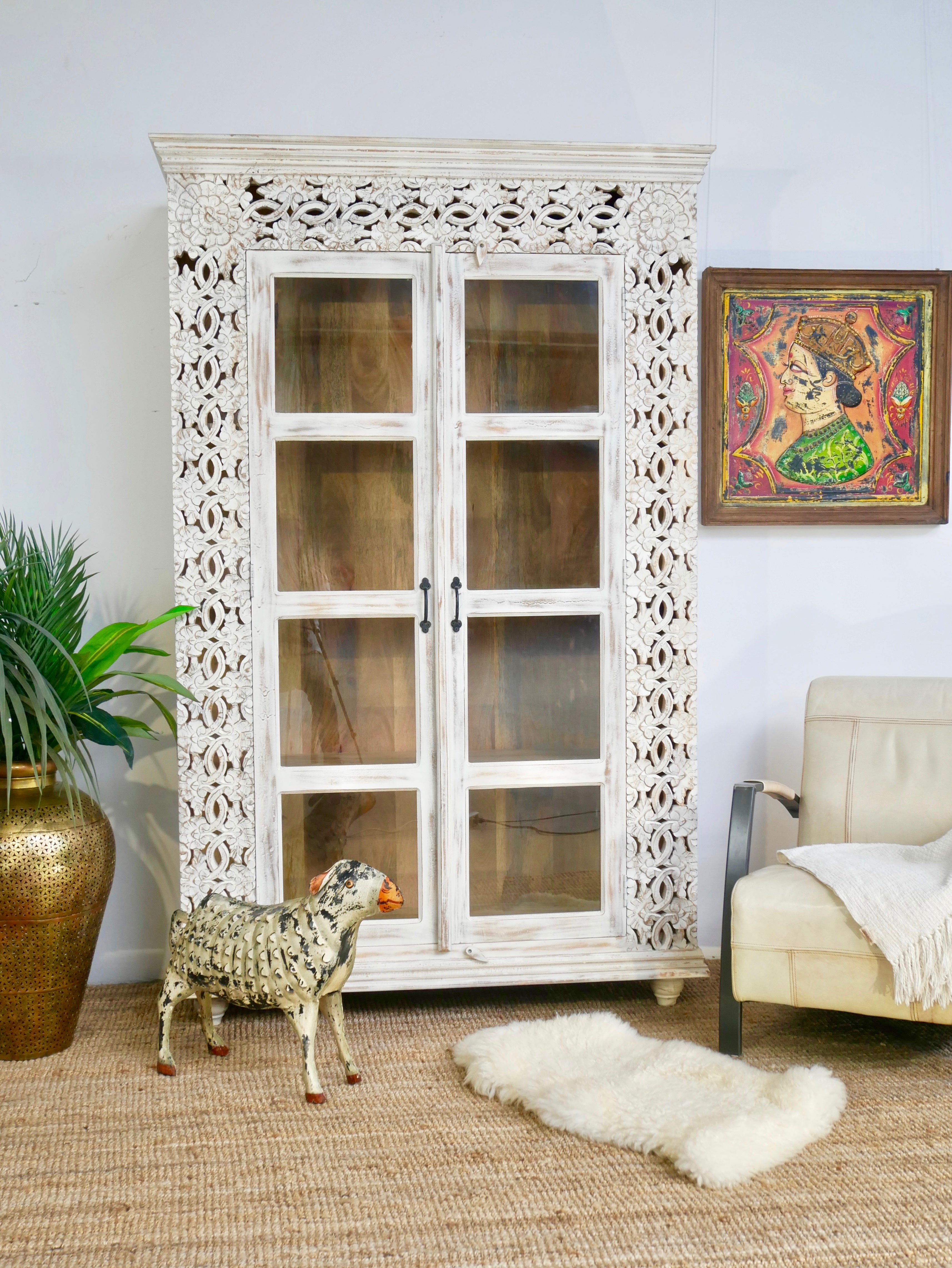 Handcrafted mango wood cabinet with glass-panelled doors and internal storage – carved wood furniture made from sustainable mango wood with unique natural grain.