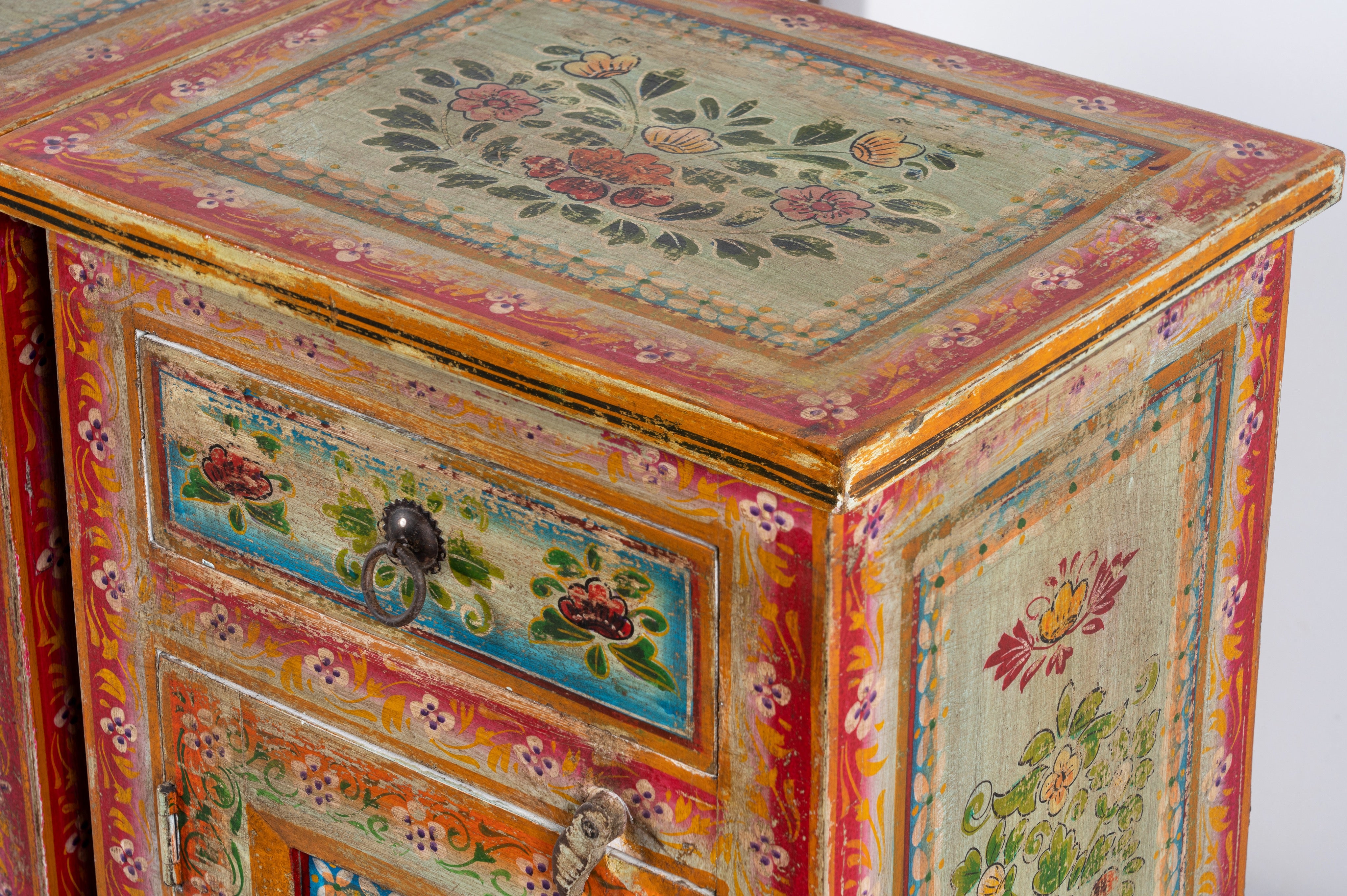 Close up image of a set of two hand painted bedside tables with floral motifs; sustainable furniture made of recycled wood, 45 × 35 × 70 cm.