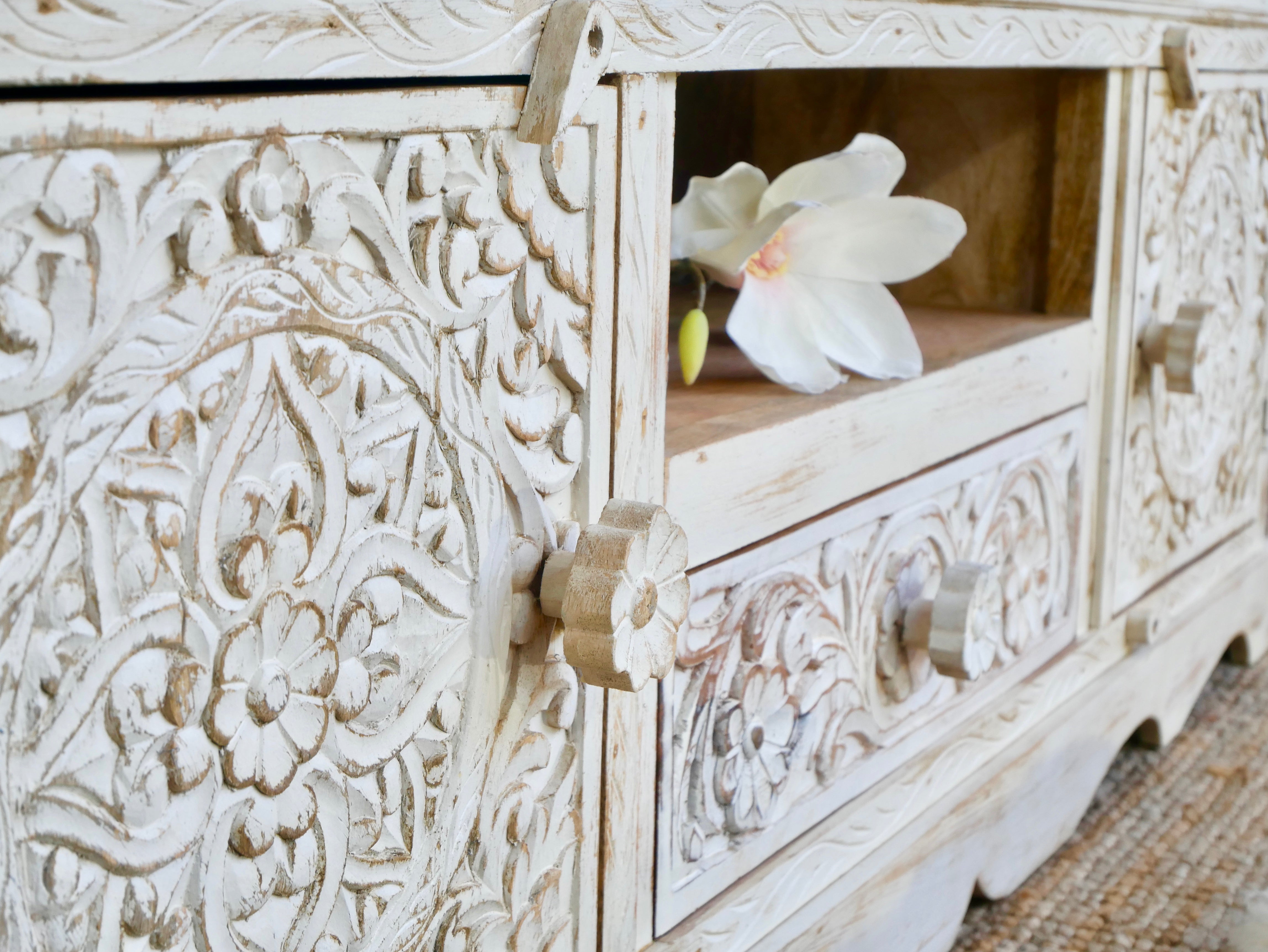 Close up image of a handcrafted wooden carved sideboard made from mango wood with Indian carvings and drawers; ideal living room furniture, 150 × 60 × 40 cm.