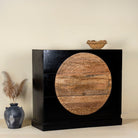 Side angle image of a mandala carved wood chest with black frame and natural carved mango wood drawers, mango wood drawer chest for modern bohemian interiors, 120 × 47 × 110 cm.
