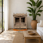 Lifestyle image of an antique reclaimed Indian teak wood house temple with hand carvings, two doors and one drawer.