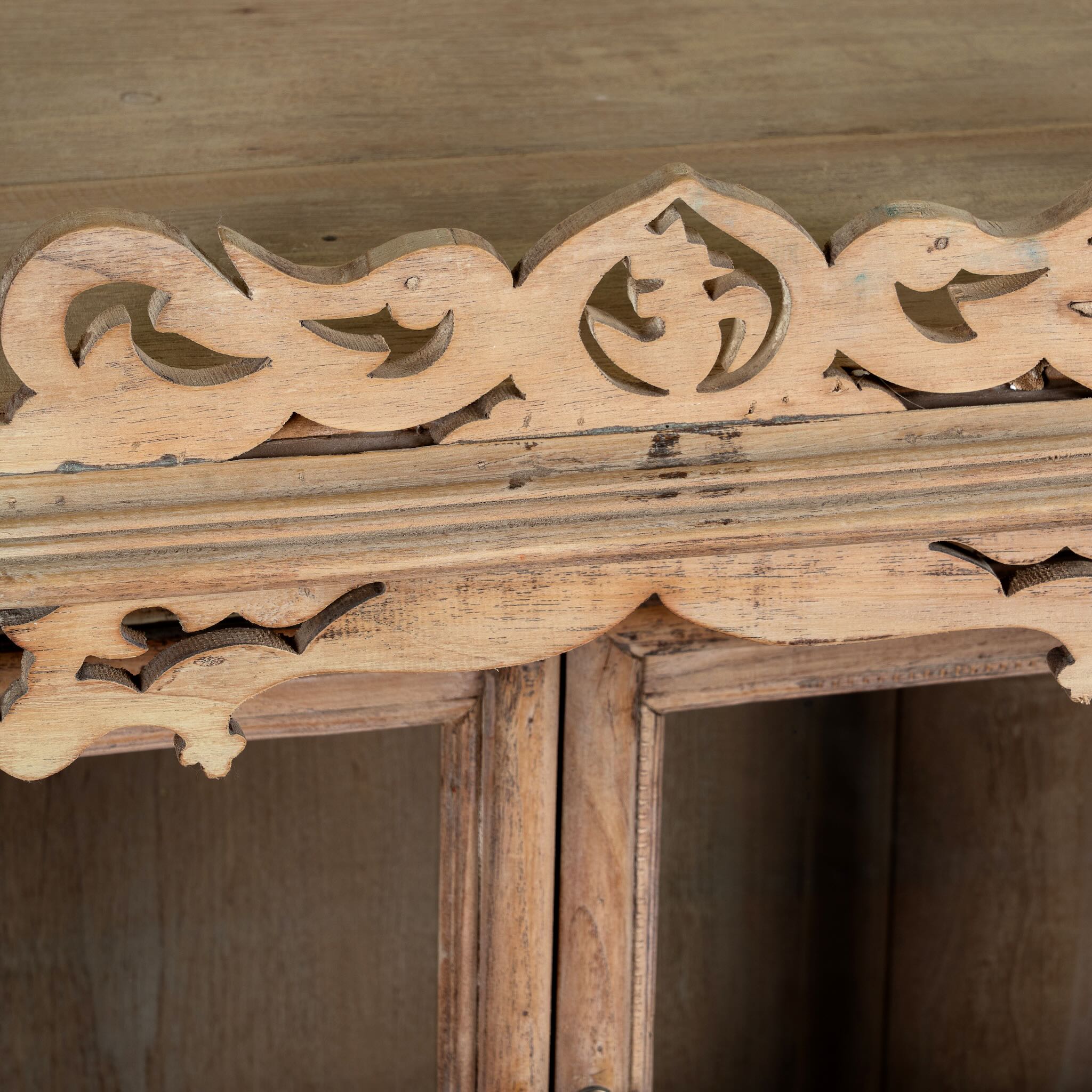 Close up image of an antique reclaimed Indian teak wood house temple with hand carvings, two doors and one drawer.